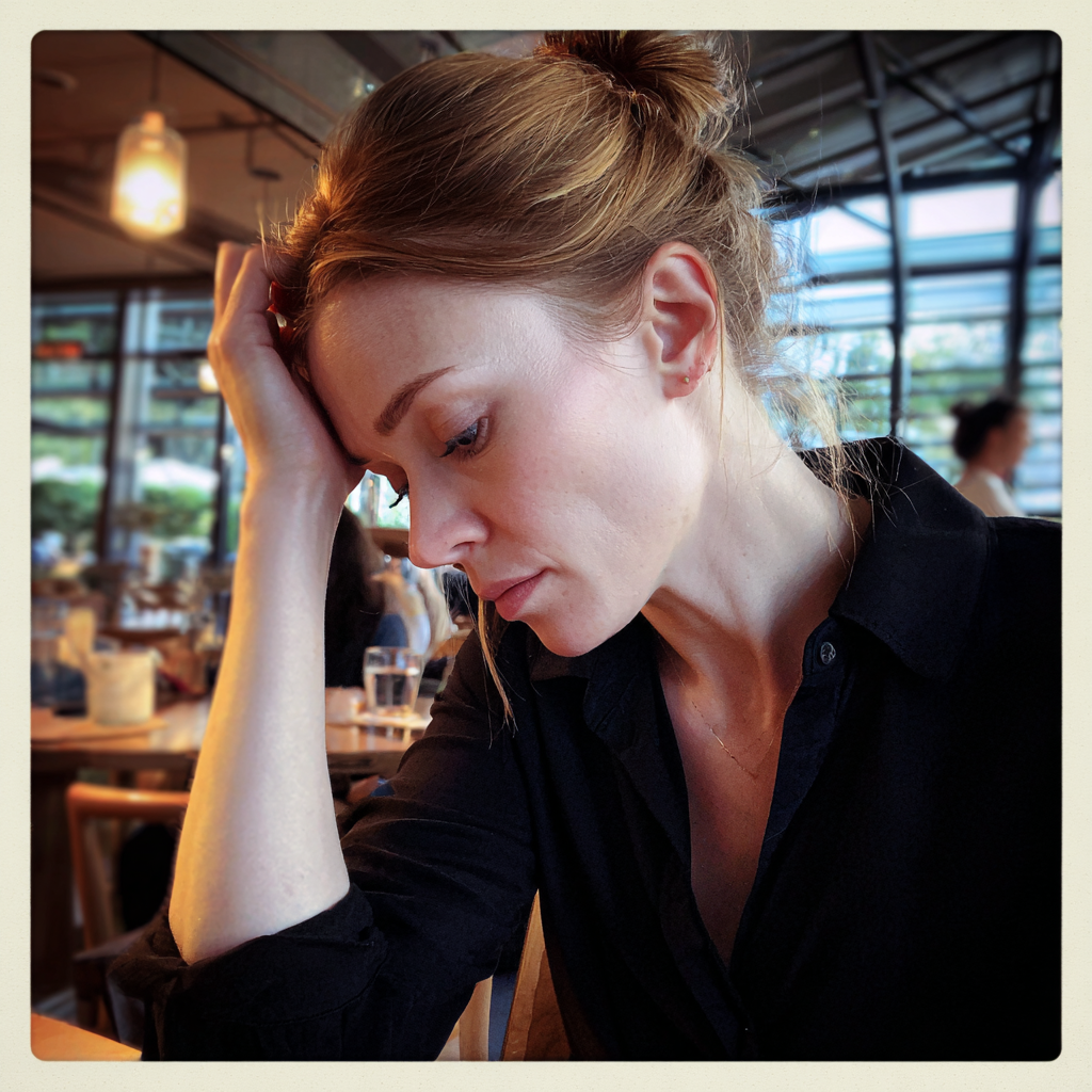 Una mujer sentada con la mano en la cabeza | Fuente: Midjourney