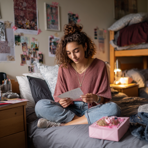 Una chica leyendo una nota en su cama | Fuente: Midjourney