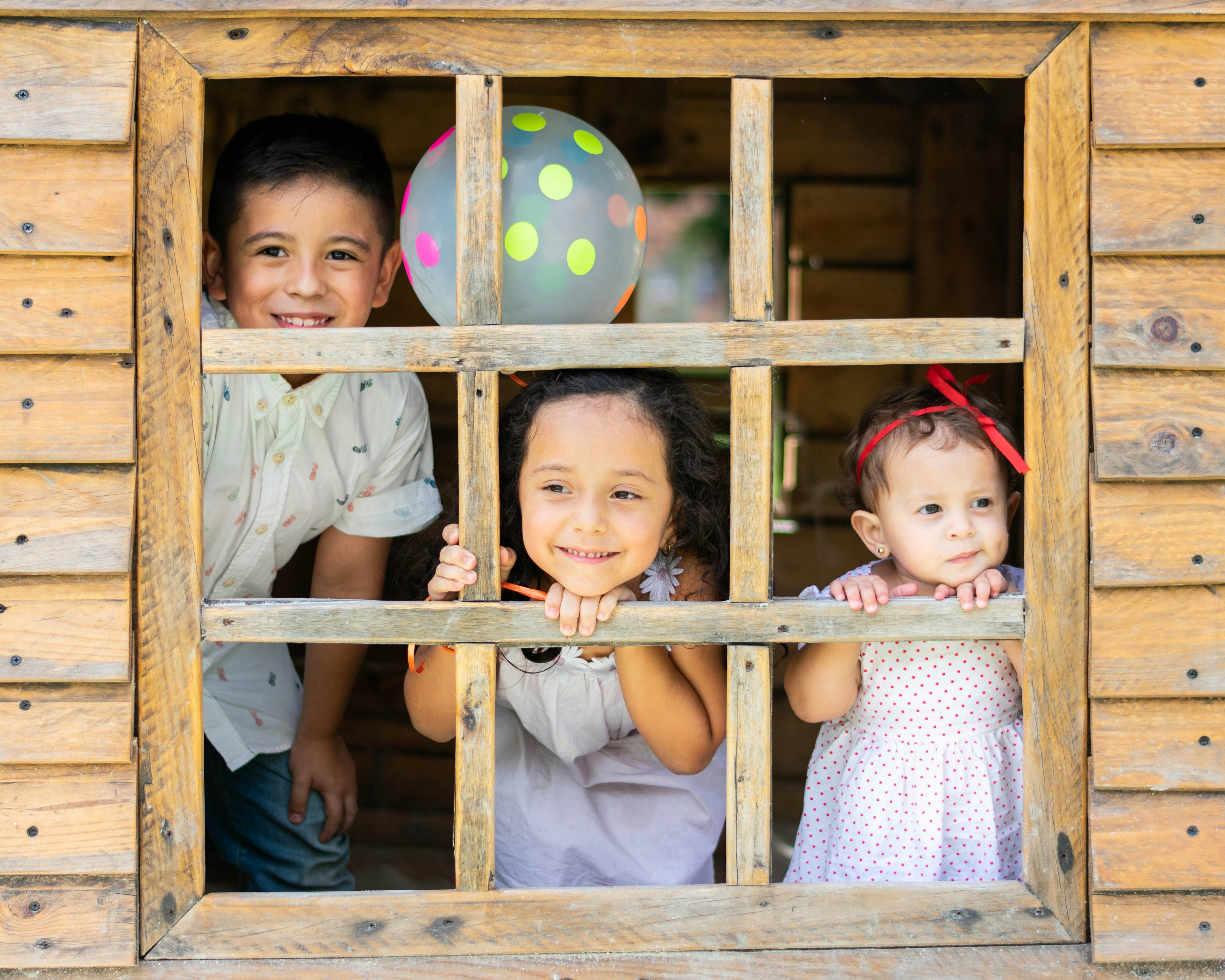 Niños en la ventana de una cabaña | Fuente: Unsplash