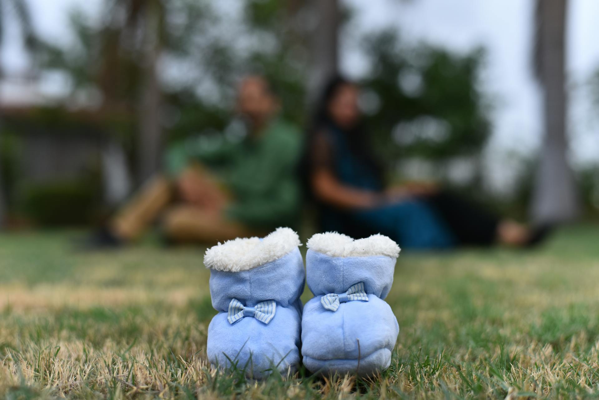 Primer plano de unos zapatos de bebé tirados en la hierba | Fuente: Pexels
