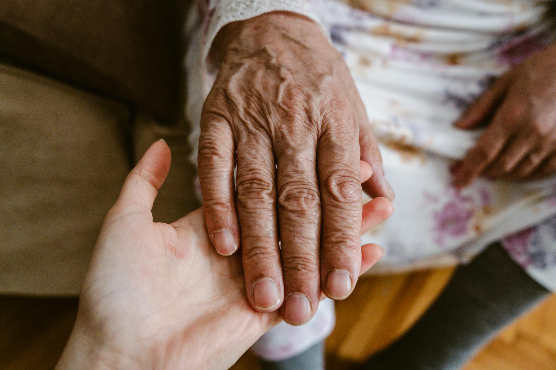 Una mujer tomando la mano de su madre | Fuente: Midjourney