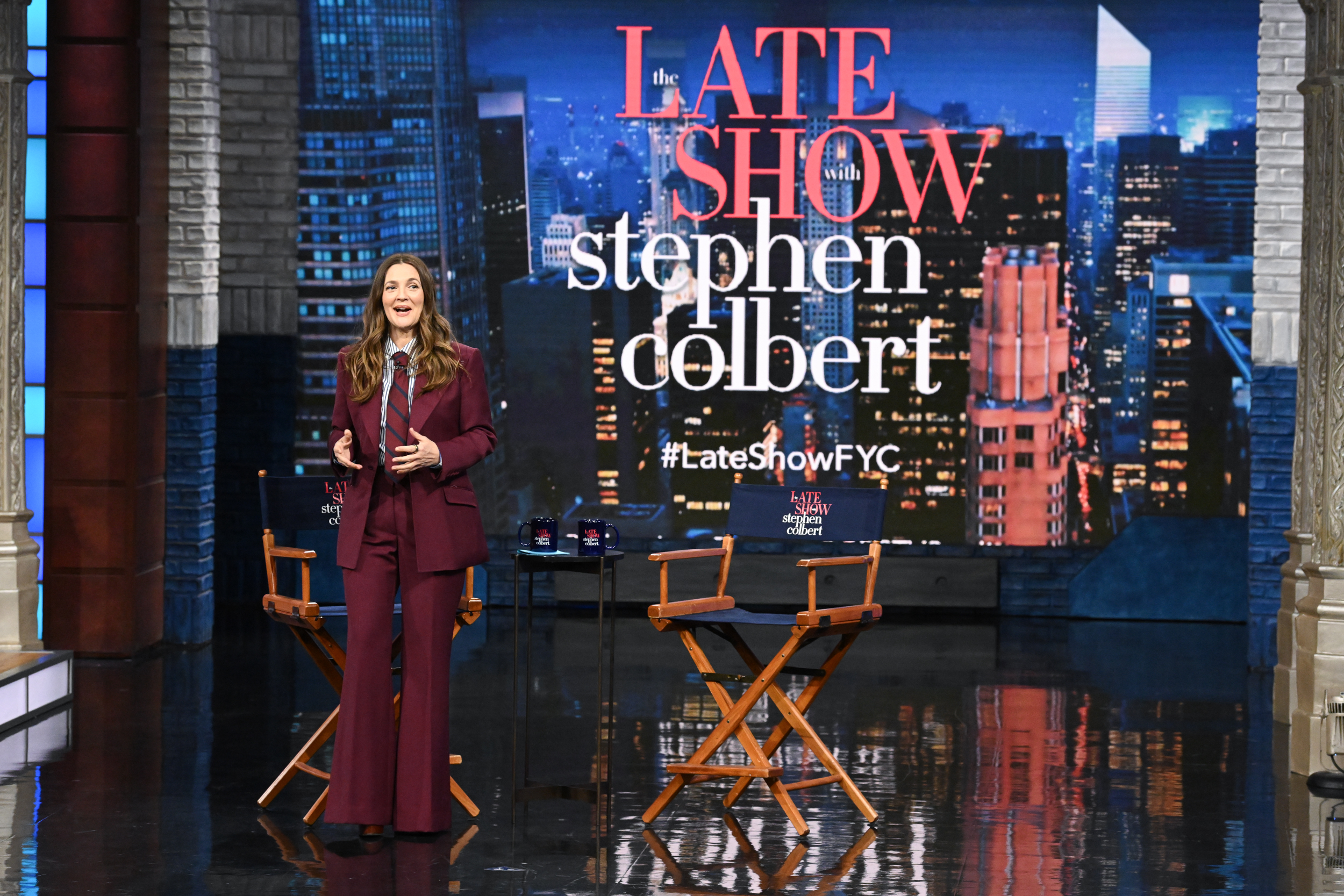 Drew Barrymore con un elegante traje burdeos mientras moderaba "The Late Show with Stephen Colbert" el 1 de mayo de 2025.