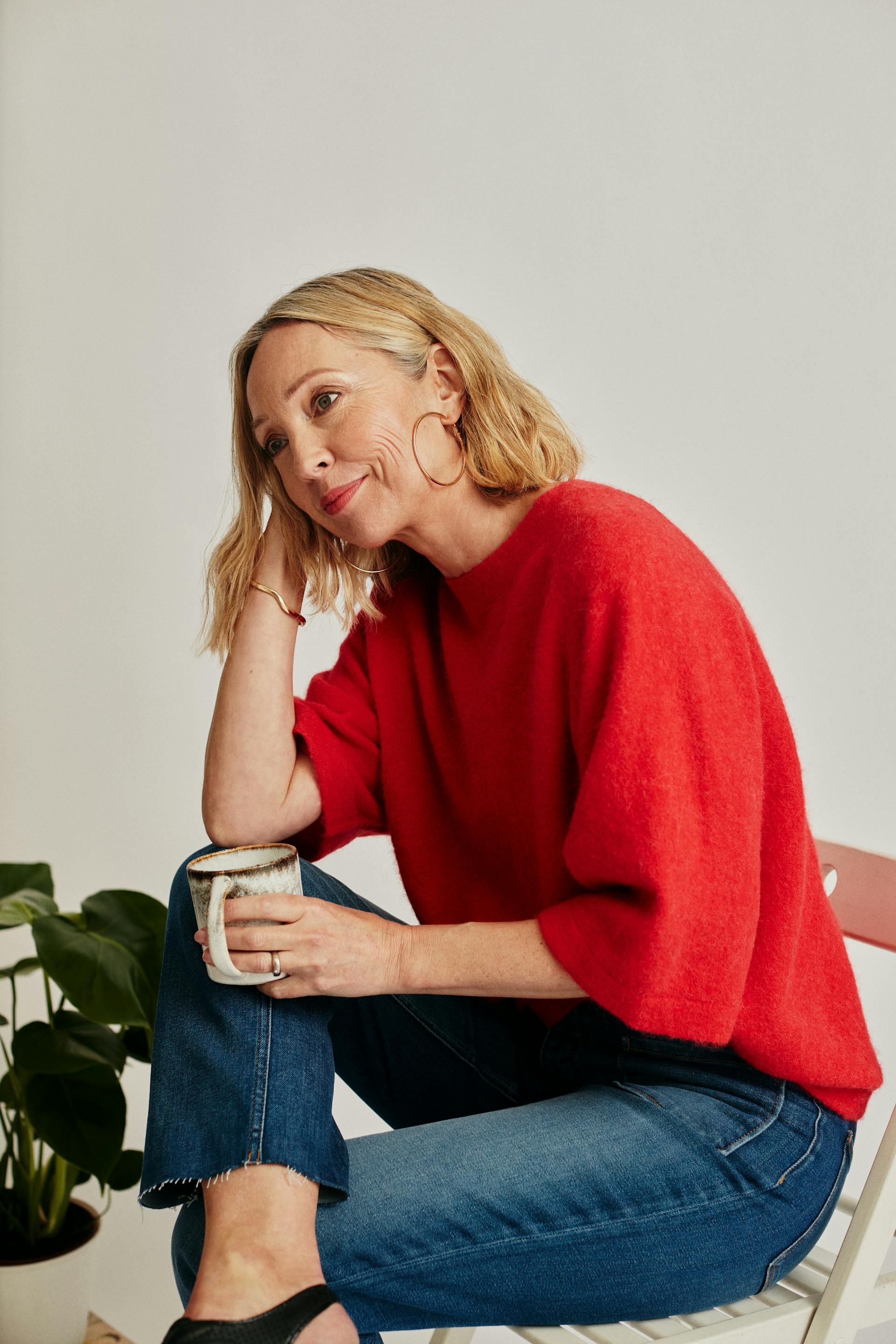 Una mujer sentada en una silla con una taza blanca | Fuente: Pexels