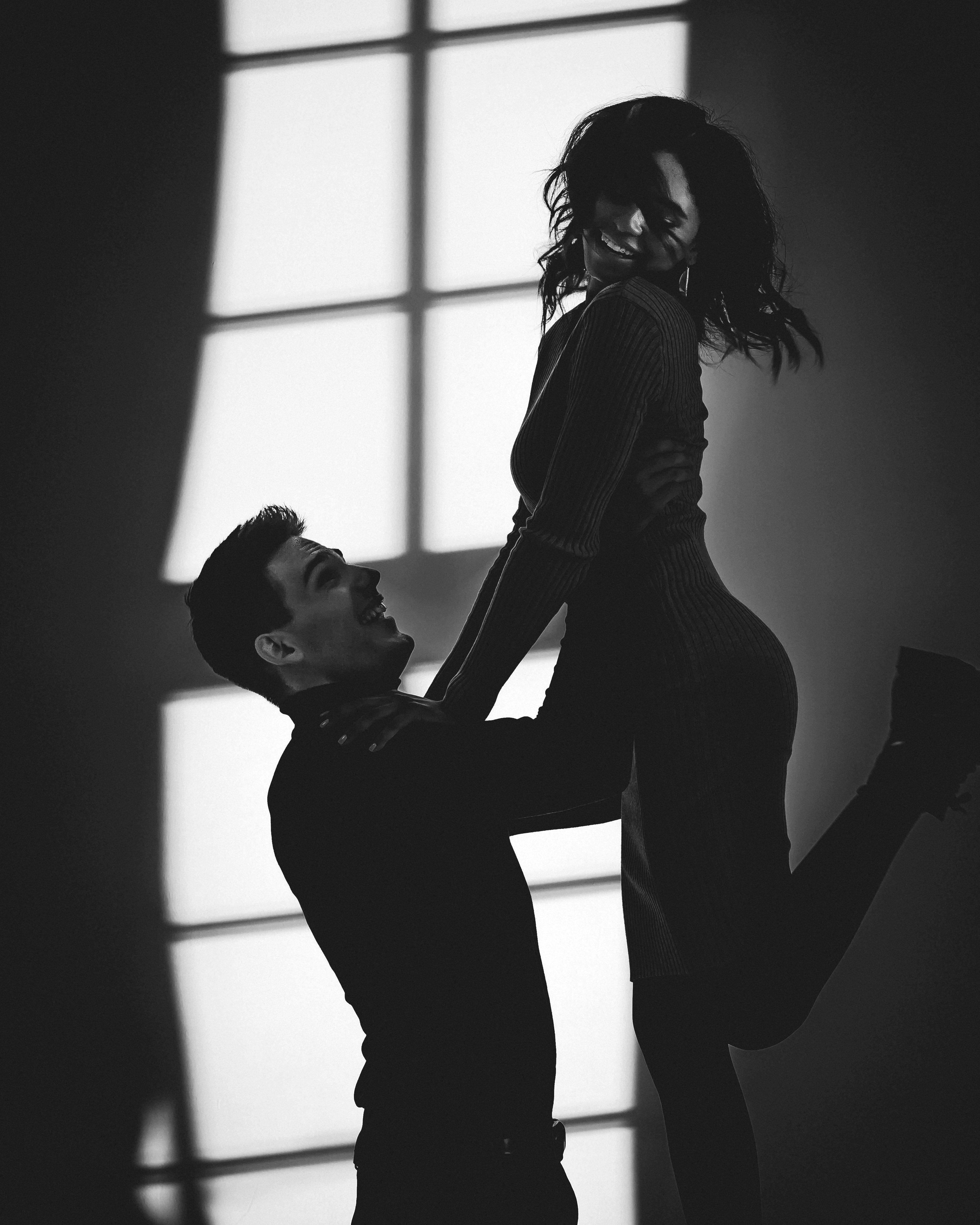 Un hombre levantando a una mujer en el aire | Fuente: Pexels