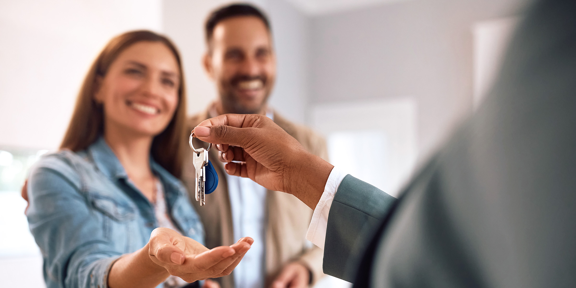 Pareja encantada recibiendo las llaves de su nueva casa | Fuente: Shutterstock