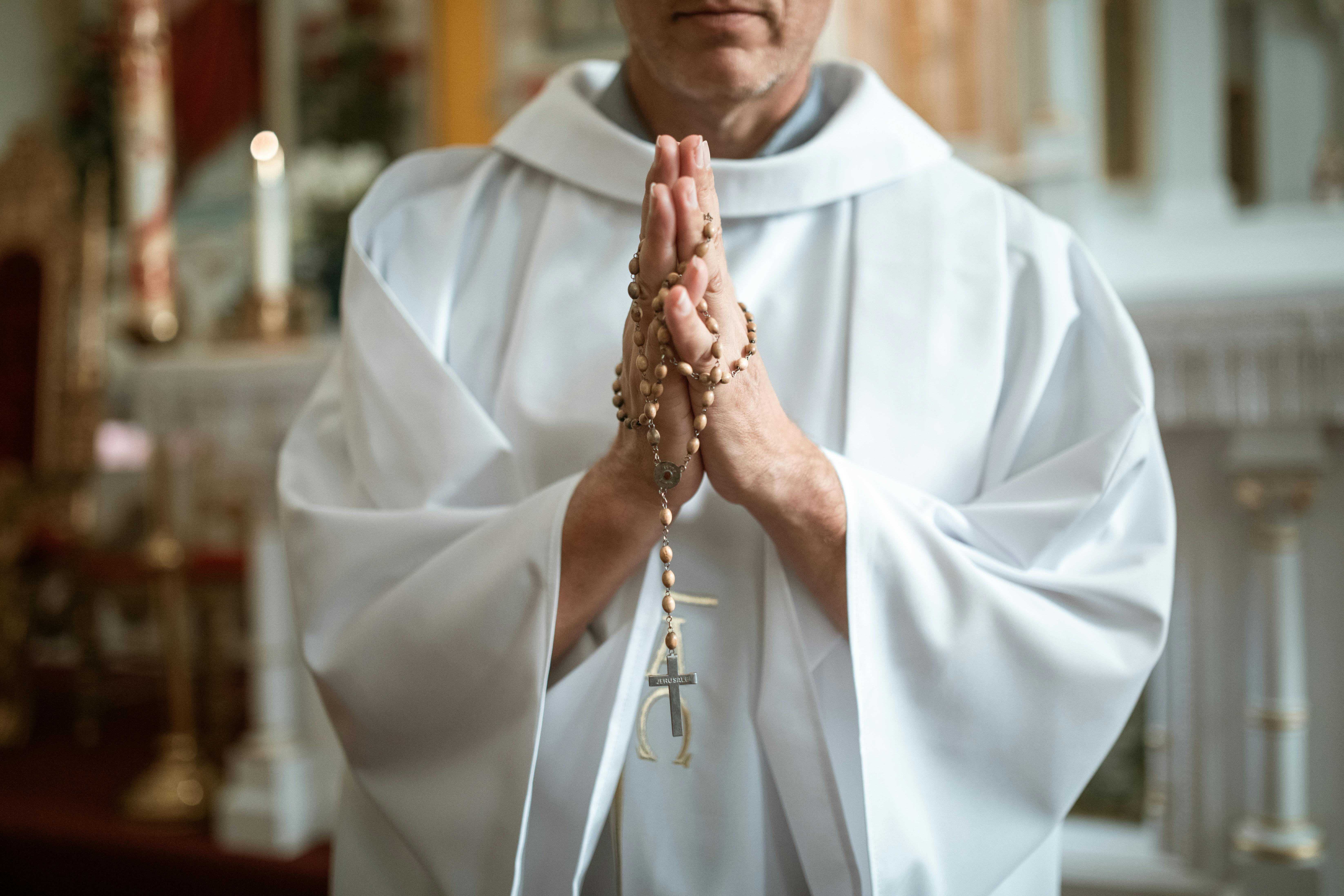 Un sacerdote sosteniendo un rosario | Fuente: Pexels