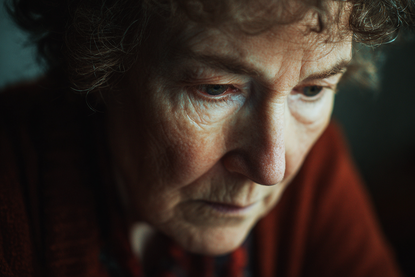 Una mujer mayor mirando hacia abajo | Fuente: Midjourney