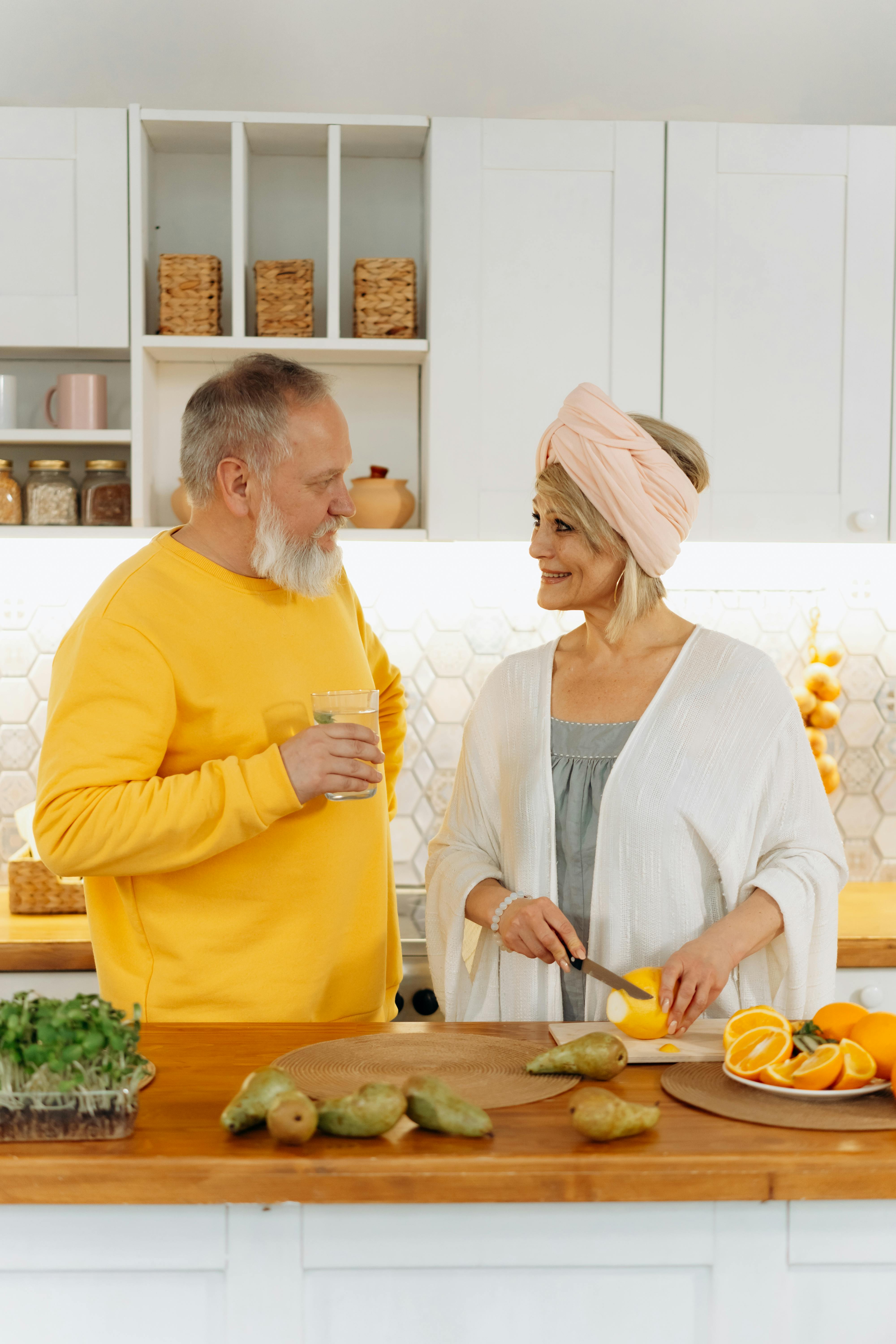 Una sonriente pareja de ancianos en una cocina | Fuente: Pexels