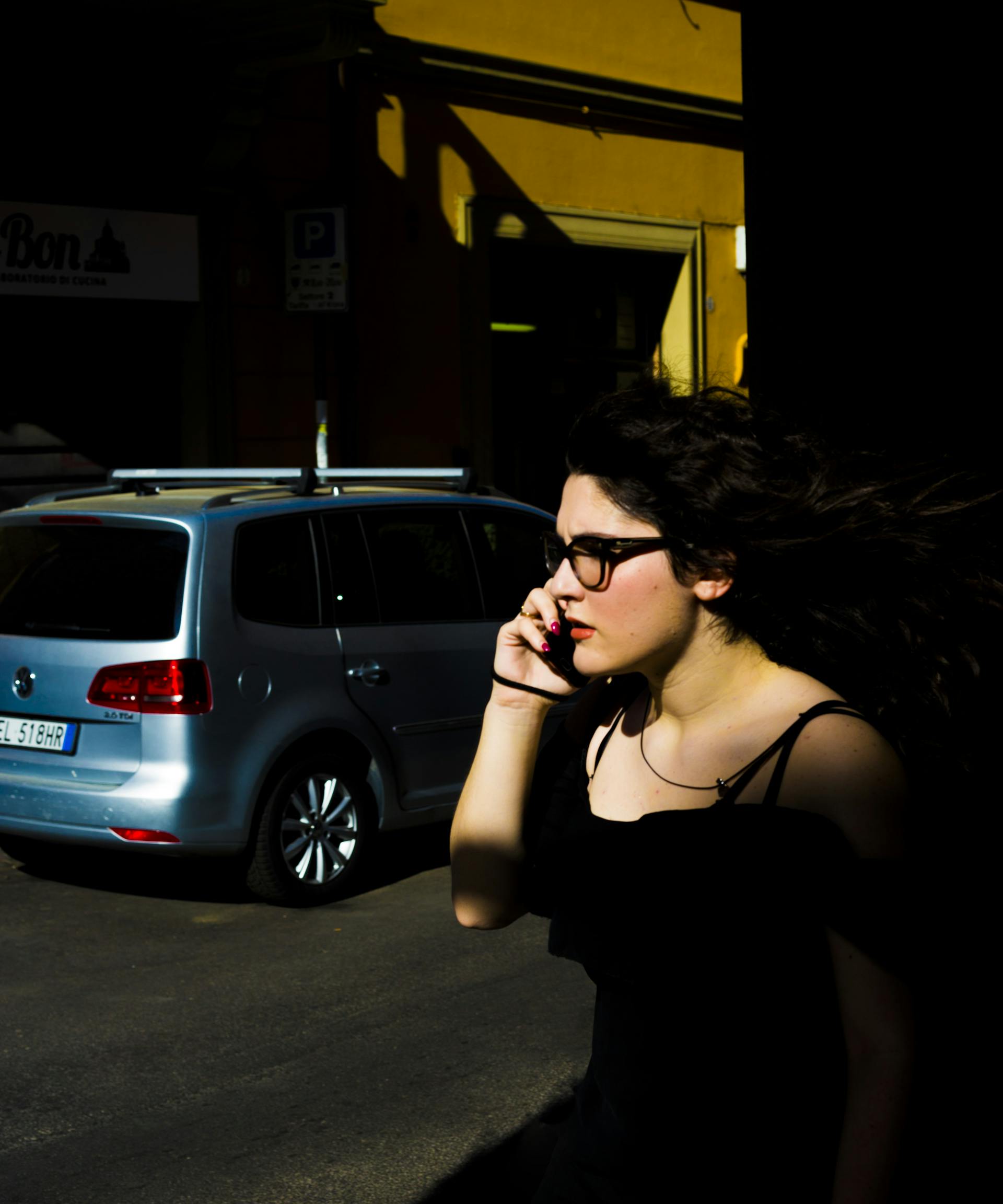 Una mujer cerca de un vehículo aparcado hablando por teléfono | Fuente: Pexels