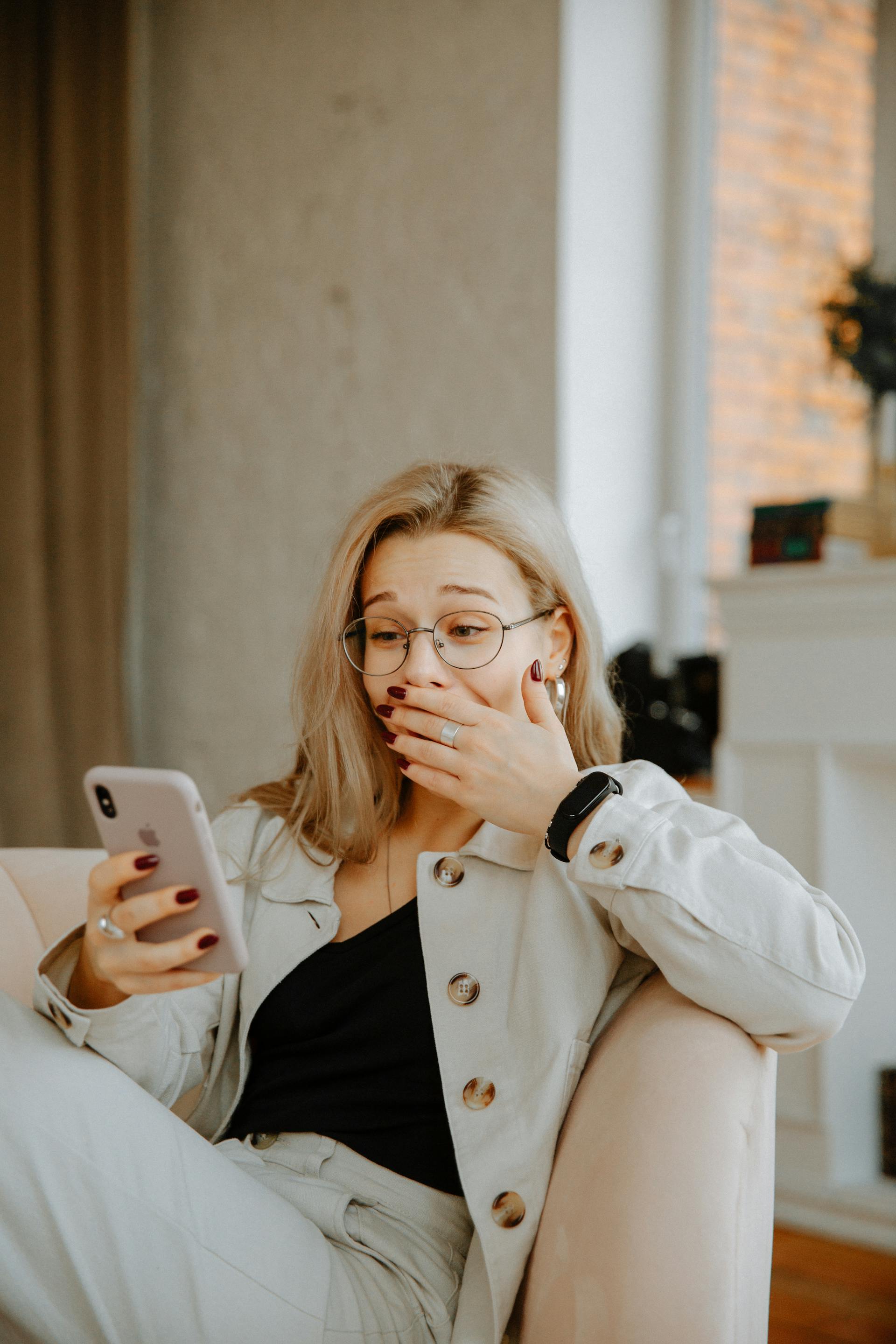 Una mujer sorprendida y divertida mirando su teléfono | Fuente: Pexels