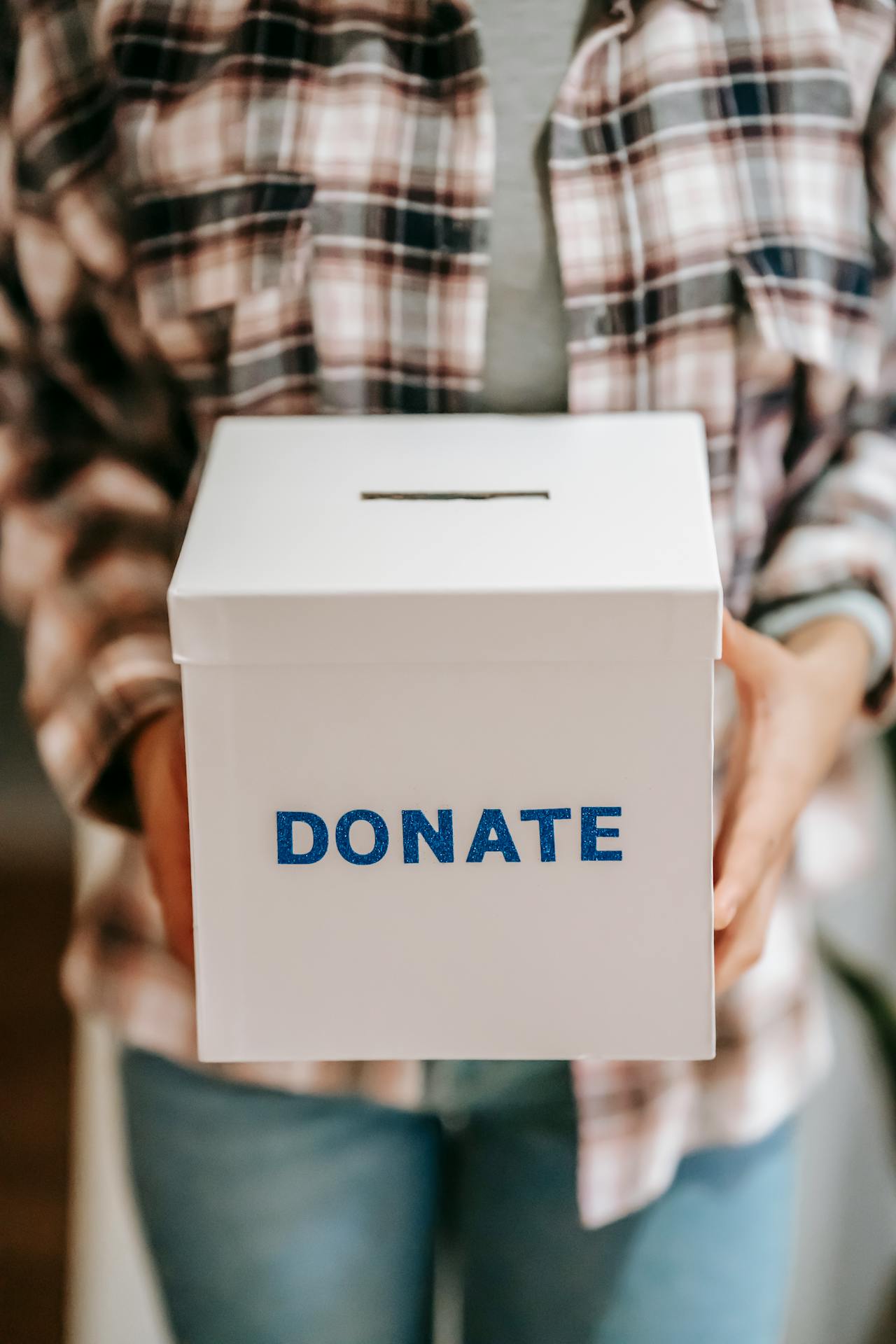 Una persona sostiene una caja de donativos | Fuente: Pexels