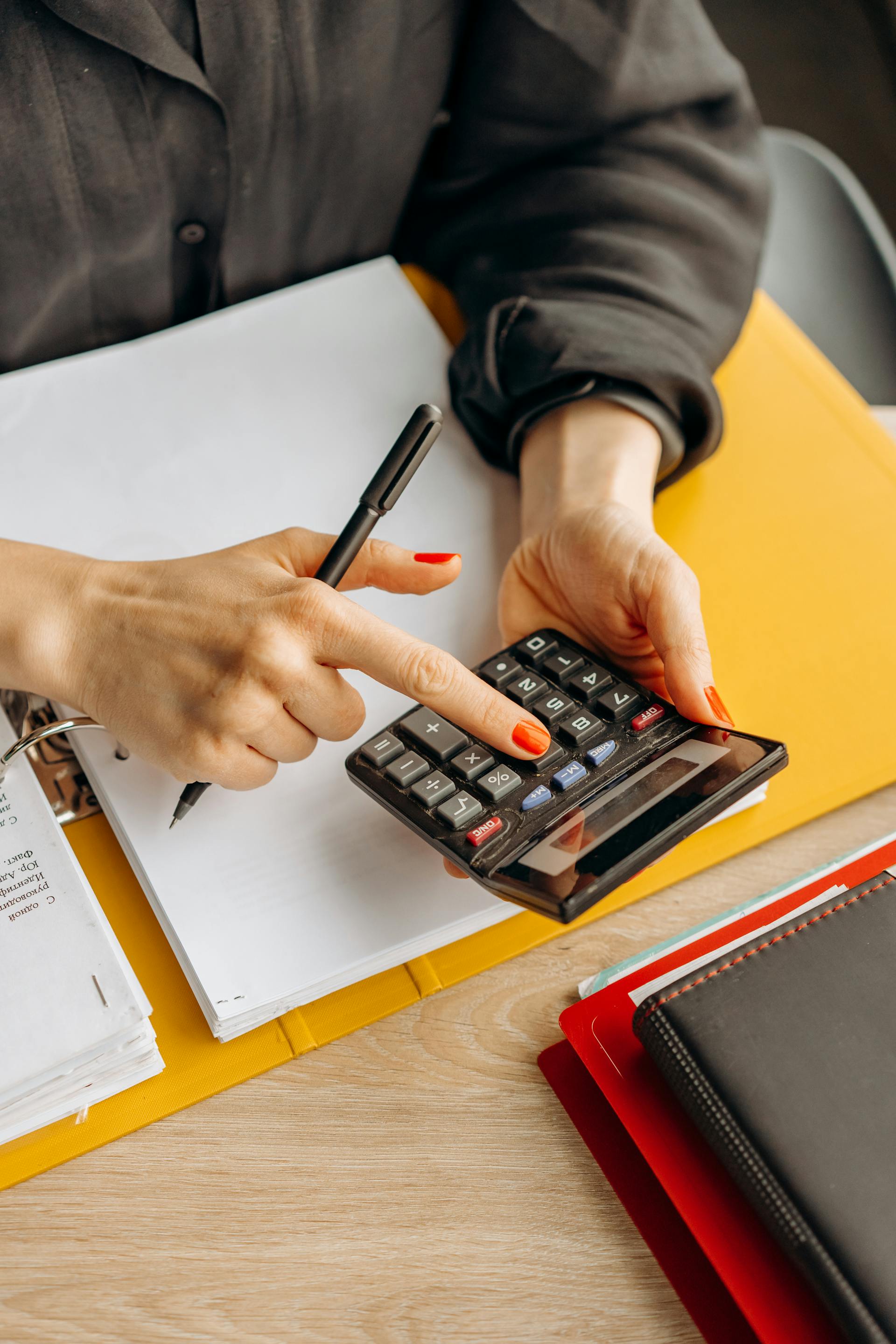 Una mujer utilizando una calculadora | Fuente: Pexels