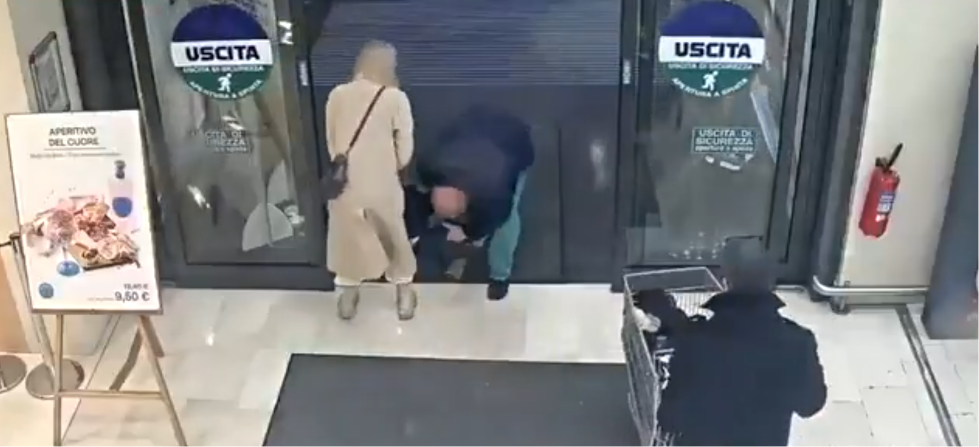 La madre con su hija en la salida del supermercado en Bergamo, Italia, mientras el hombre se agacha para arrebatarle a la menor de 1 año | Fuente: X/vox_occidental