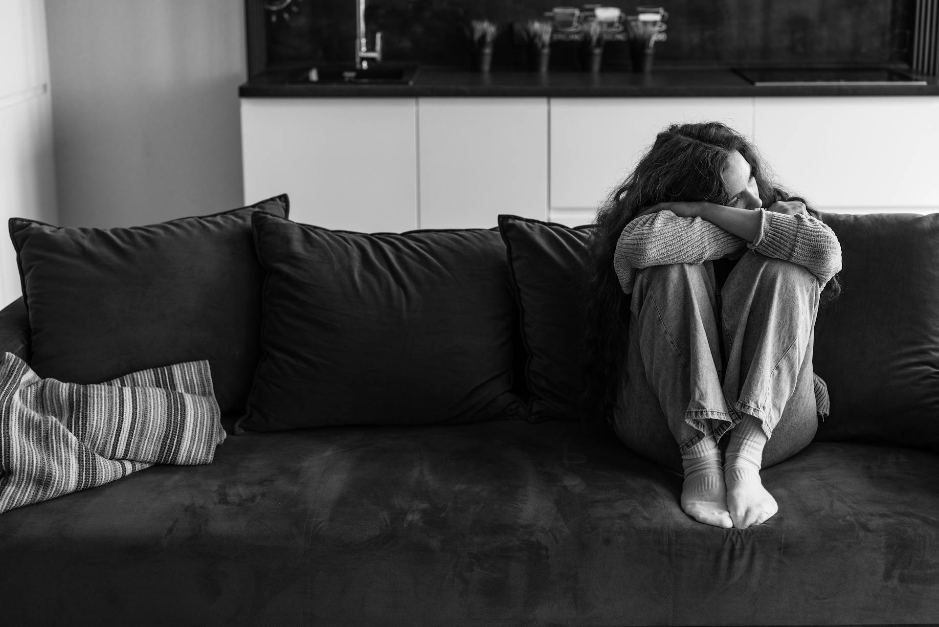 Una mujer triste sentada en el sofá | Fuente: Pexels