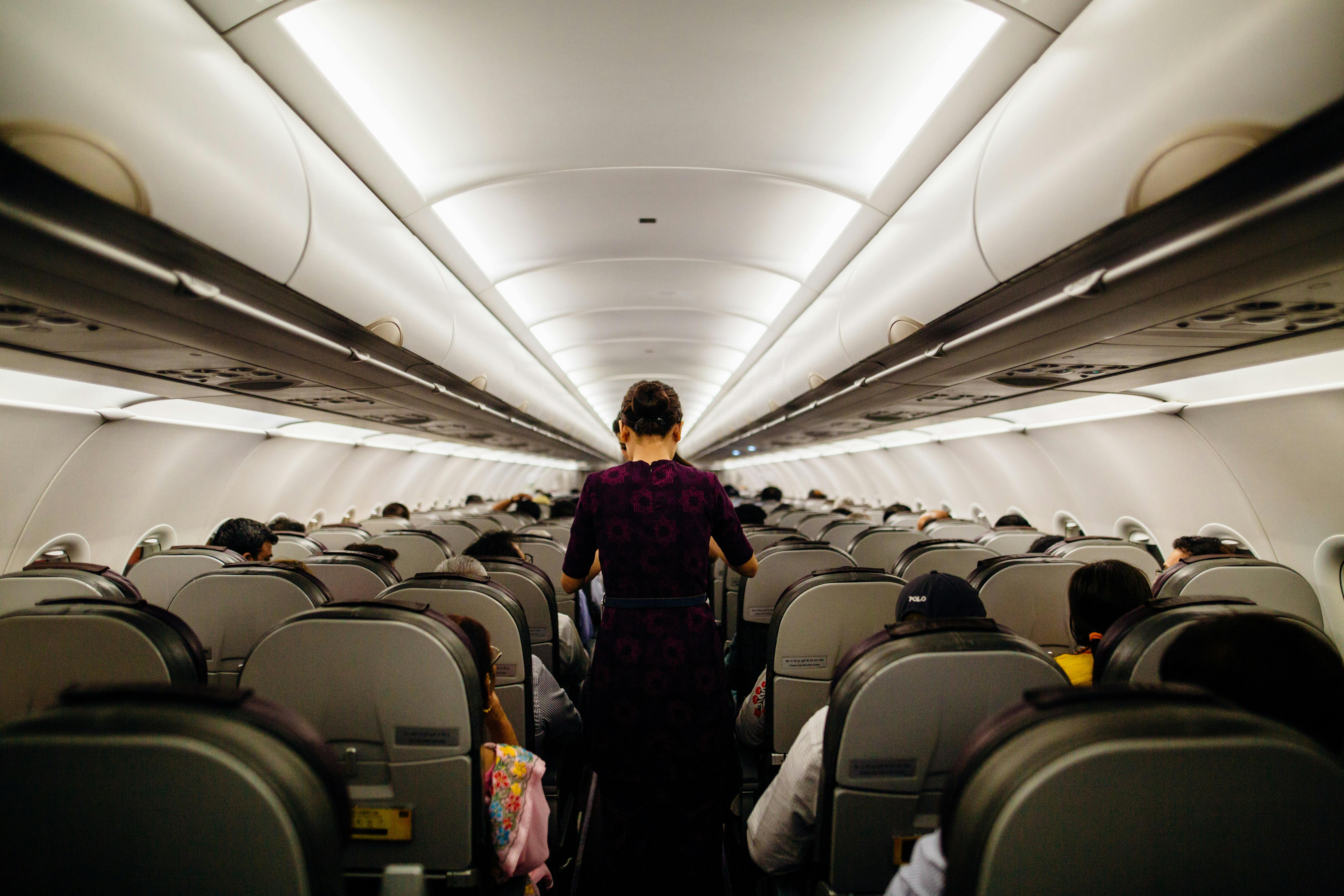 Una azafata de pie en el pasillo de un avión | Fuente: Pexels