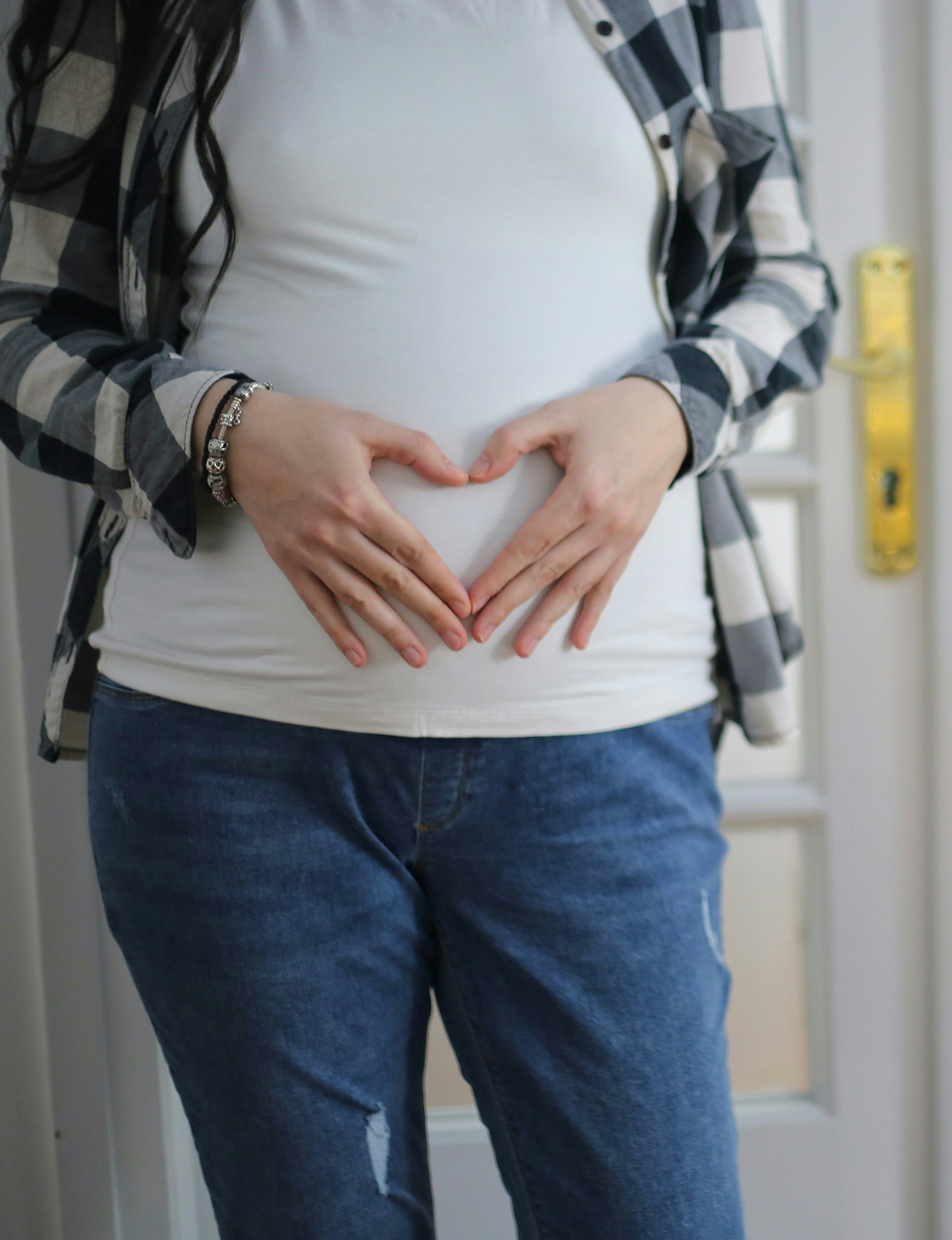 Una mujer con las manos colocadas sobre el estómago | Fuente: Unsplash