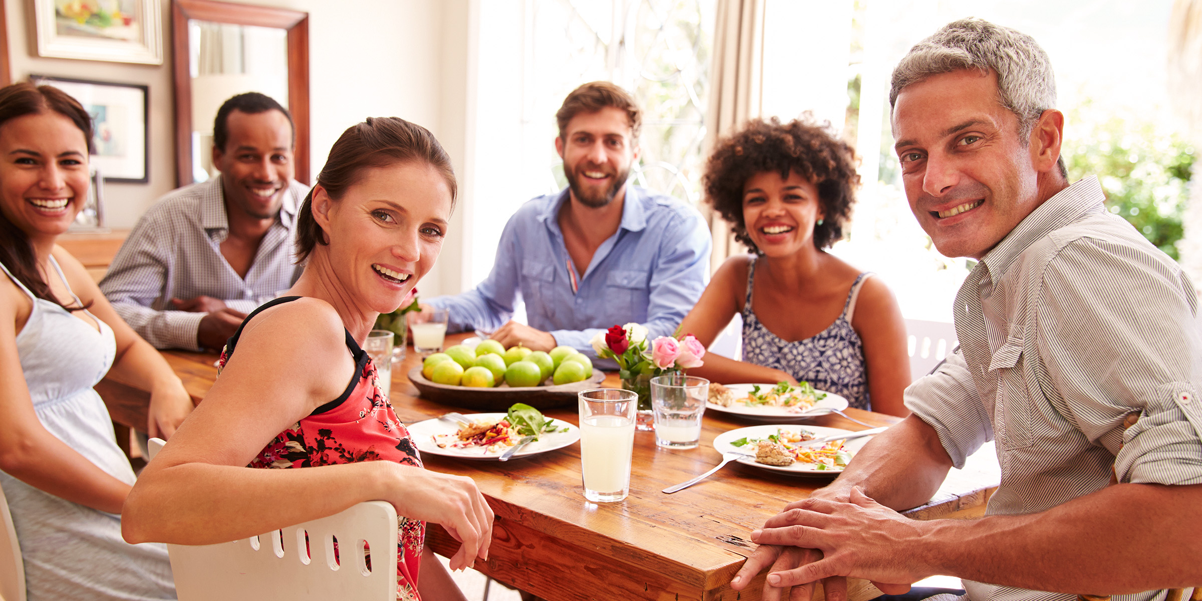 Gente sentada alrededor de una mesa | Fuente: Shutterstock