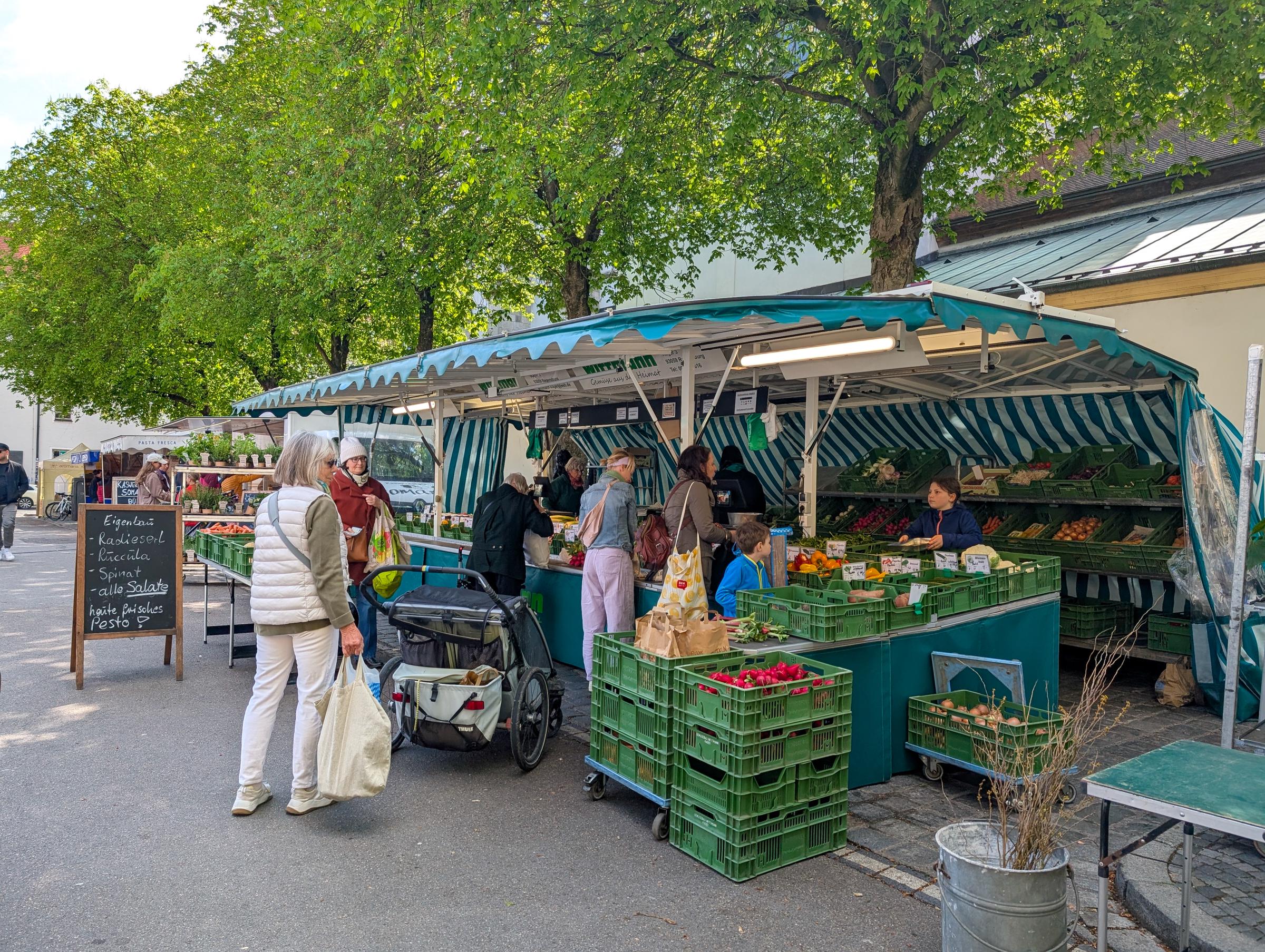 Unos compradores adquieren verduras, frutas y hierbas frescas en un mercado de productos al aire libre | Fuente: Getty Images