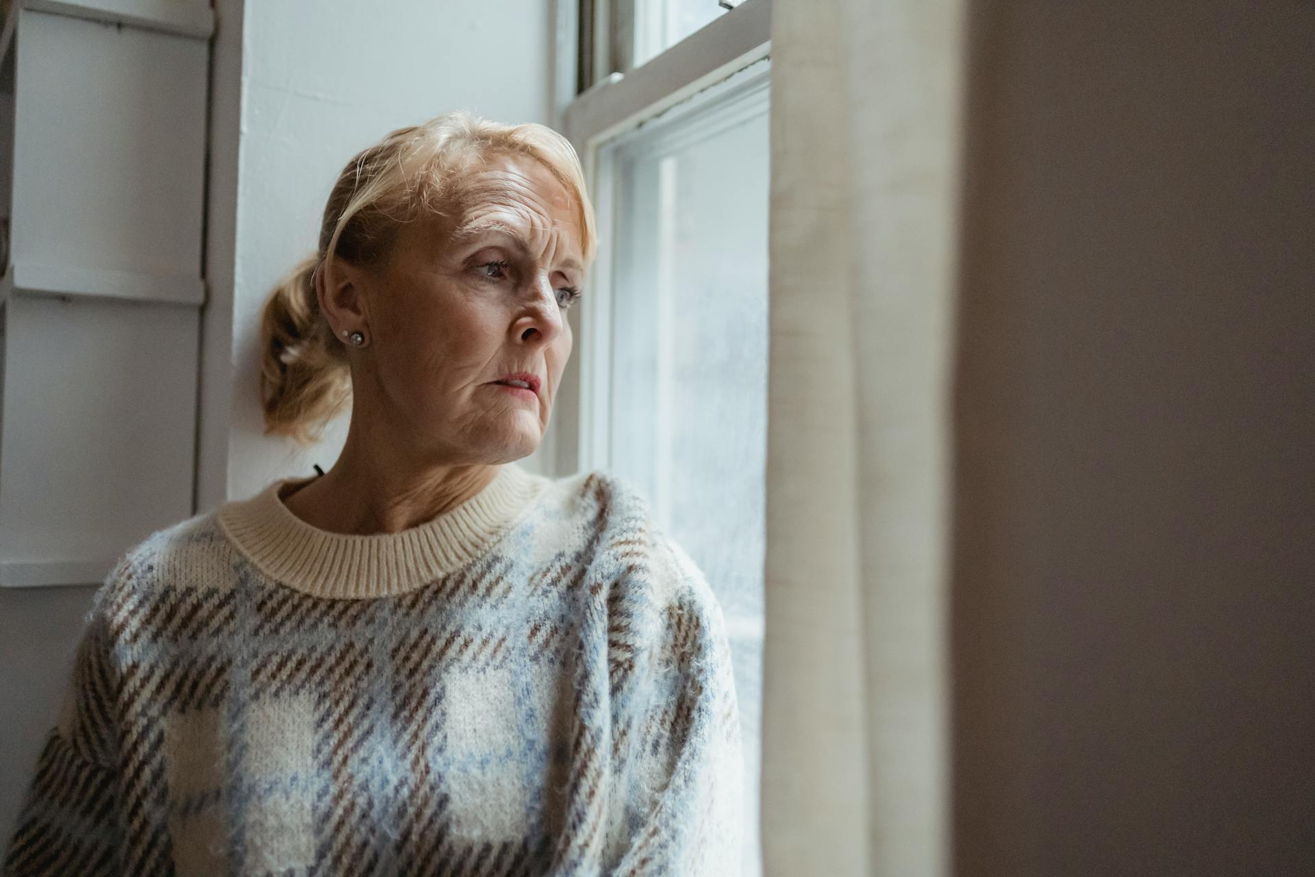 Una mujer mirando por la ventana | Fuente: Pexels