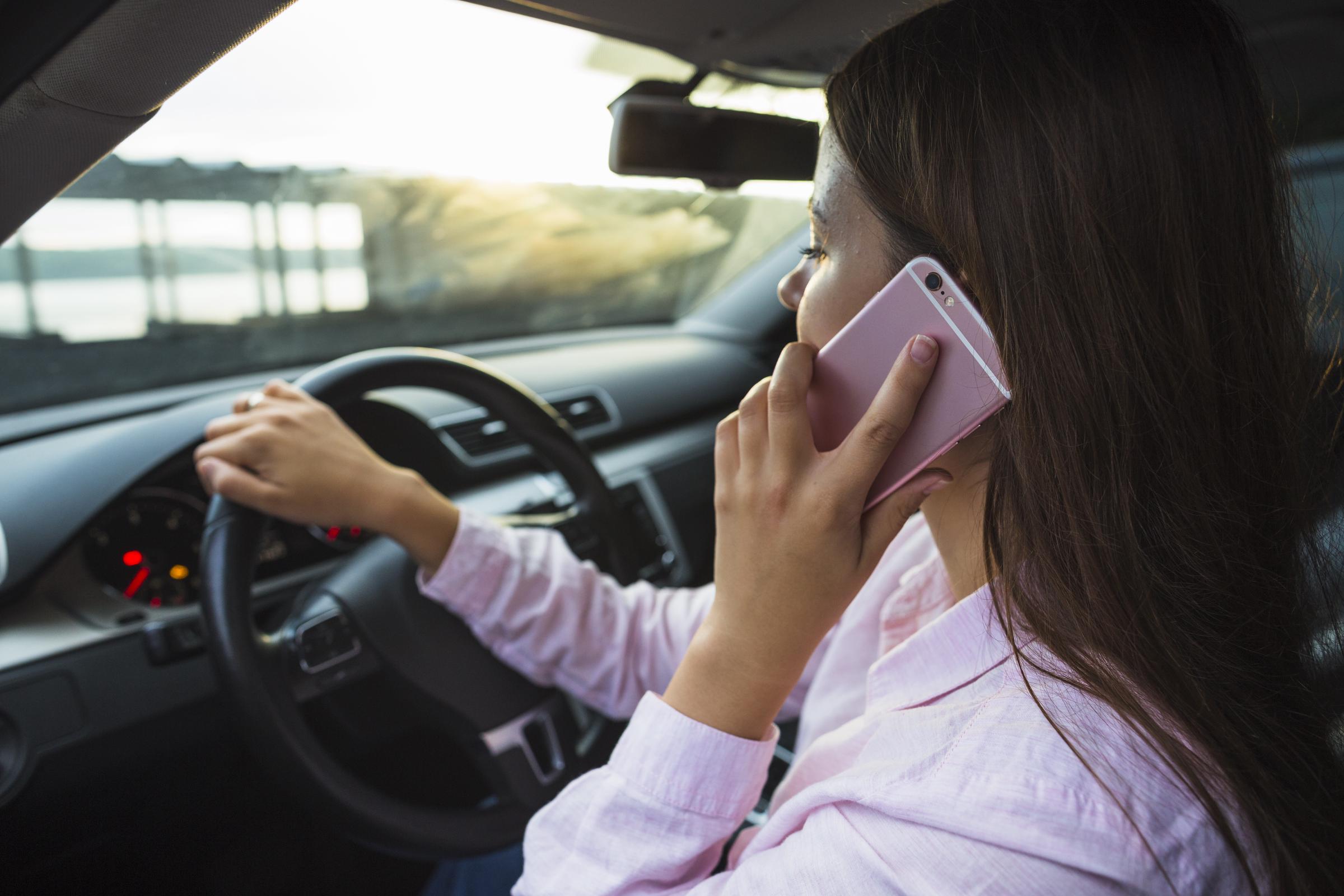Una mujer sentada en su automóvil hablando por teléfono | Fuente: Freepik