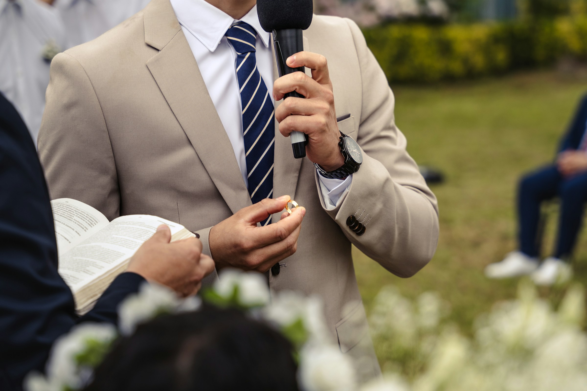 Un hombre trajeado sujetando un micrófono | Fuente: Unsplash
