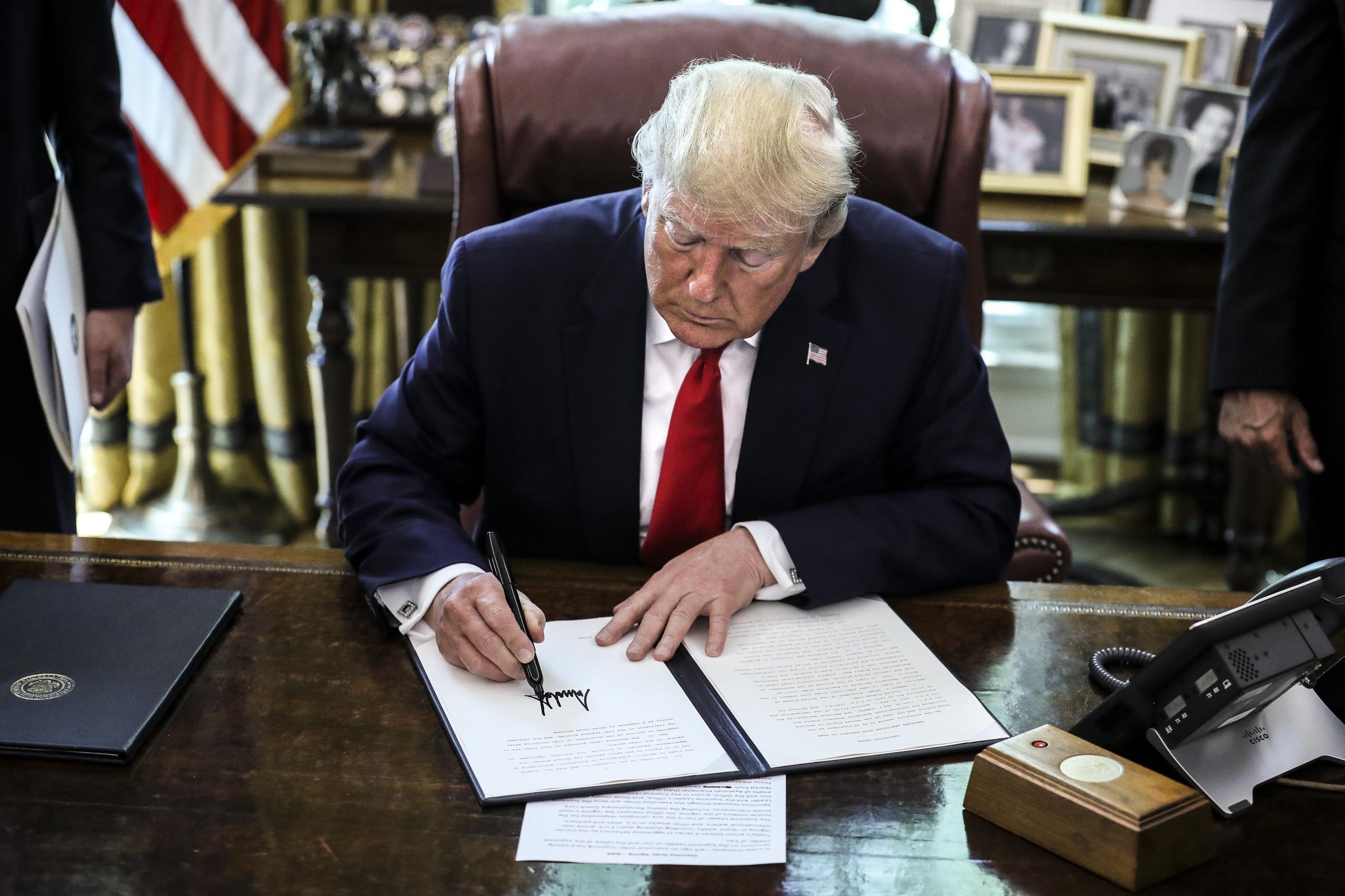 El presidente Donald Trump firma una orden ejecutiva que impone nuevas sanciones a Irán en el Despacho Oval de la Casa Blanca el 24 de junio de 2019, en Washington, DC. | Fuente: Getty Images