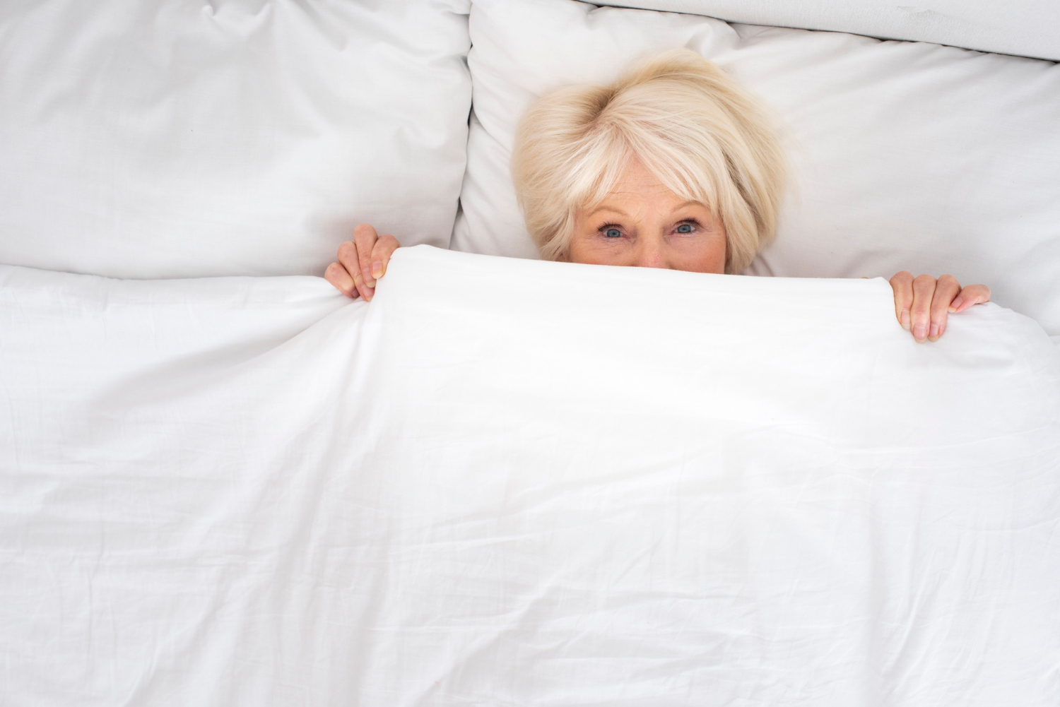 Una anciana asustada tumbada en su cama | Fuente: Freepik