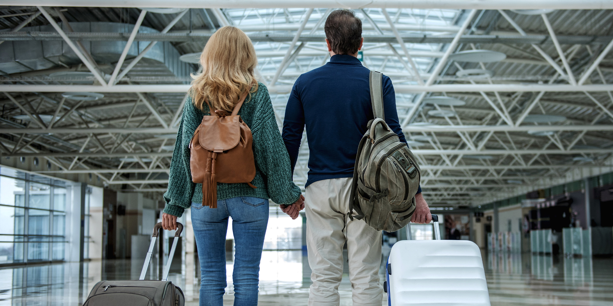 Una pareja de la mano en un aeropuerto | Fuente: Shutterstock