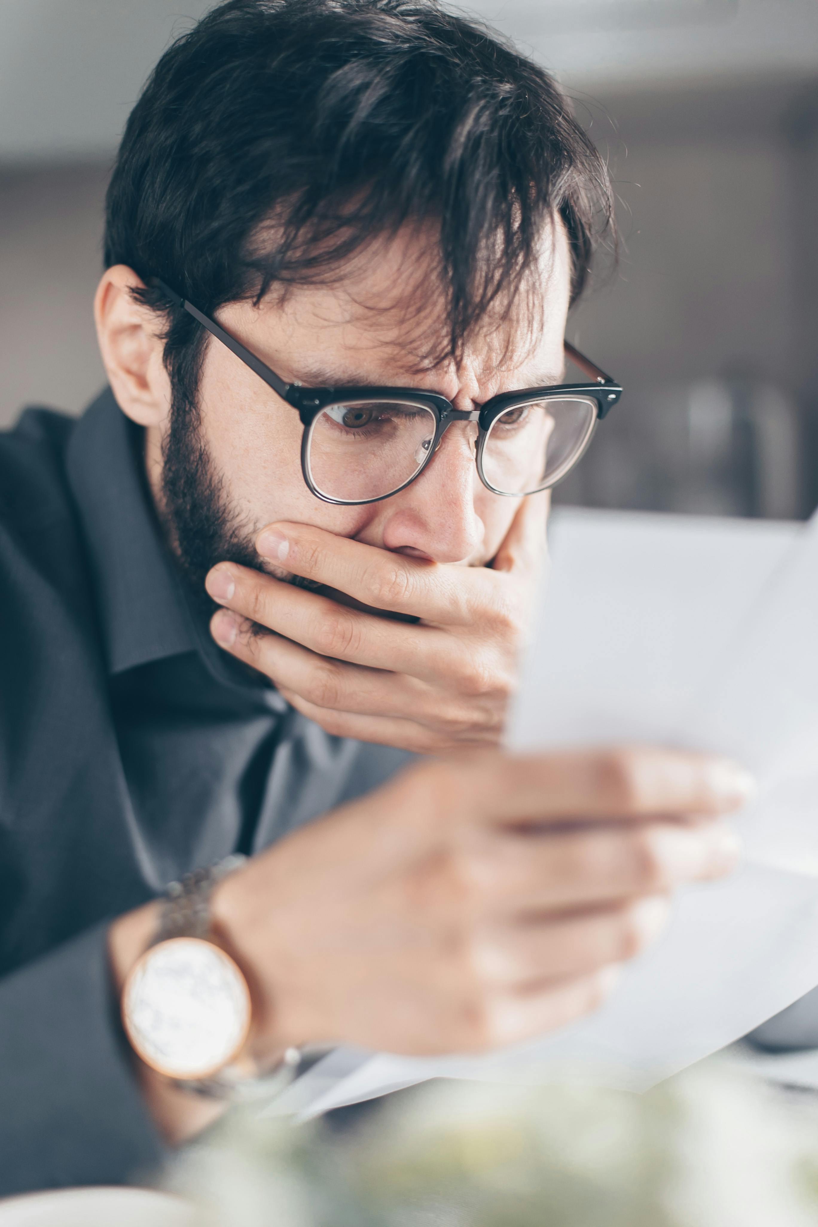 Un hombre conmocionado leyendo una nota | Fuente: Pexels
