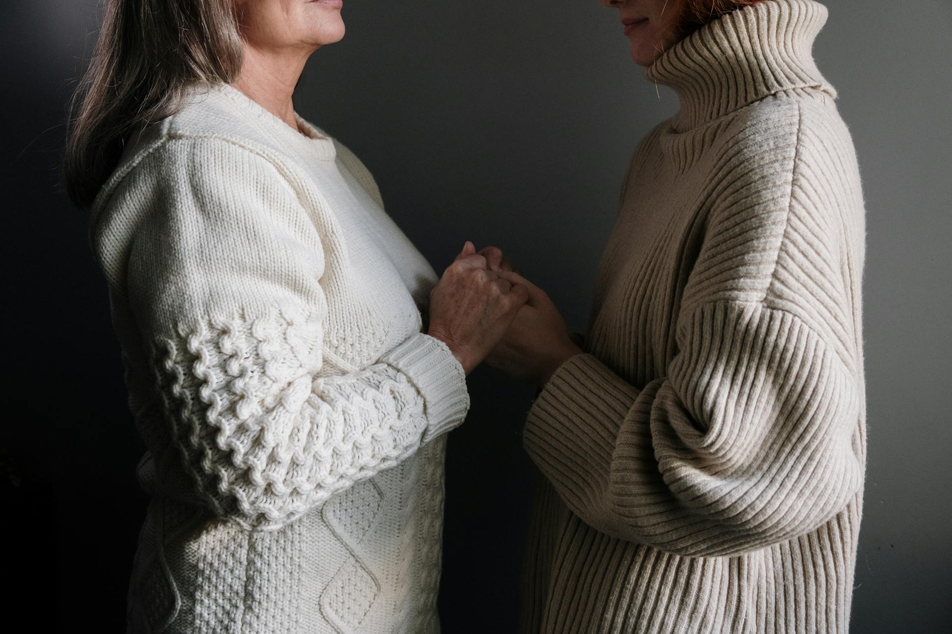 Una mujer cogiendo las manos de su hija | Fuente: Pexels