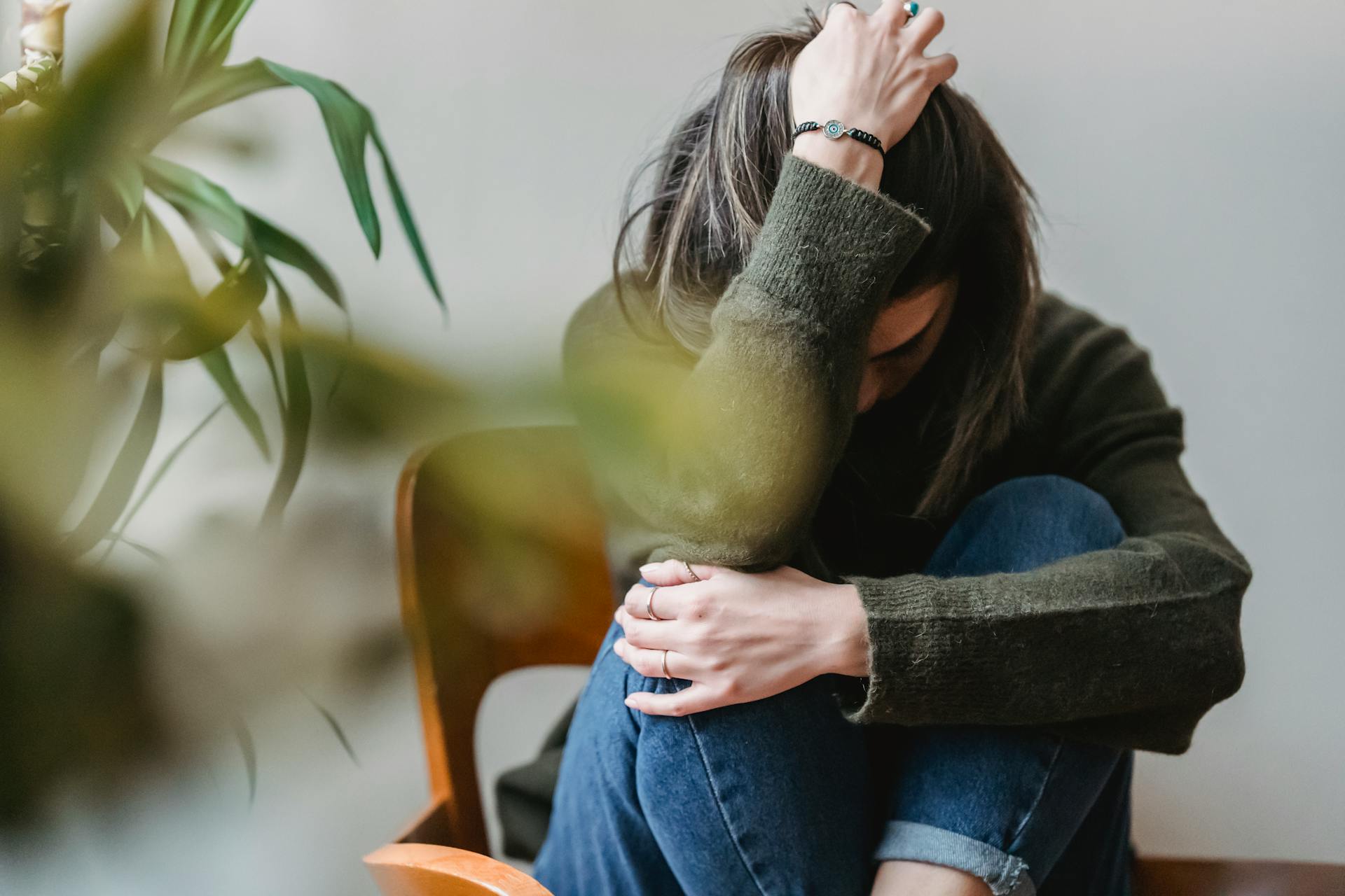 Una mujer sentada con la cabeza en una mano | Fuente: Pexels