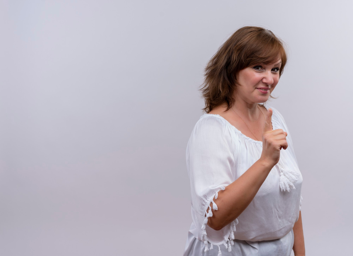Una mujer sonriente señalando con el dedo | Fuente: Freepik