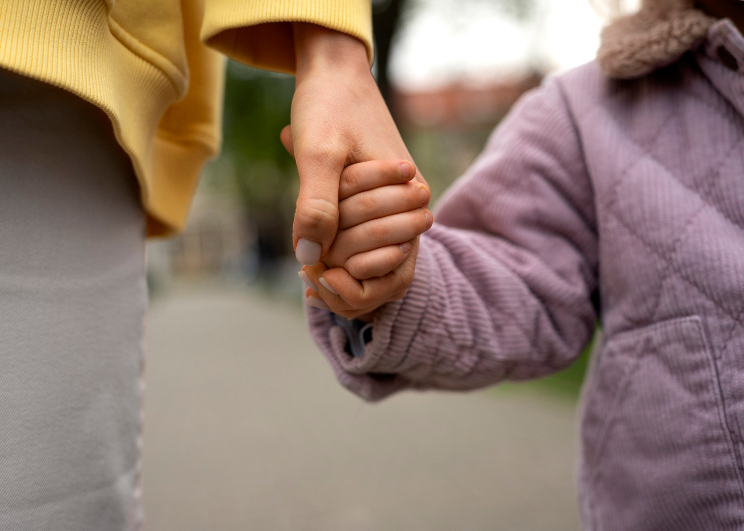Una mujer tomando la mano a un niño | Fuente: Freepik