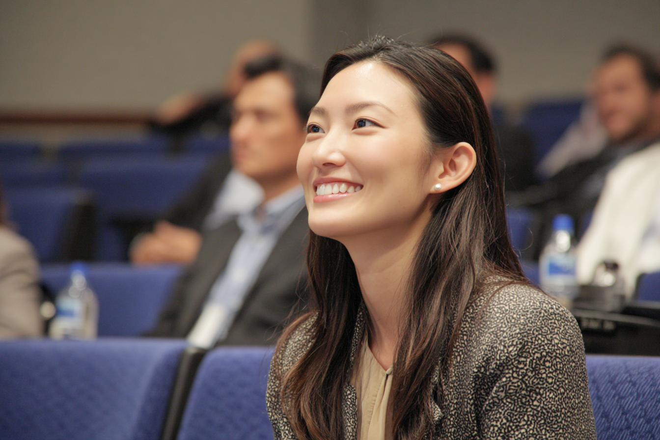 Una mujer en un auditorio sonriendo | Fuente: Midjourney