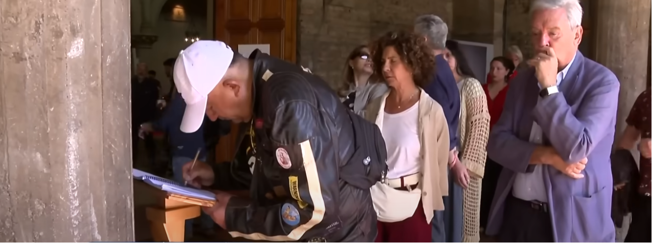 Personas esperando a la salida de la capilla para firmar el libro de condolencias del difunto actor Héctor Noguera | Fuente: YouTube/Teletrece