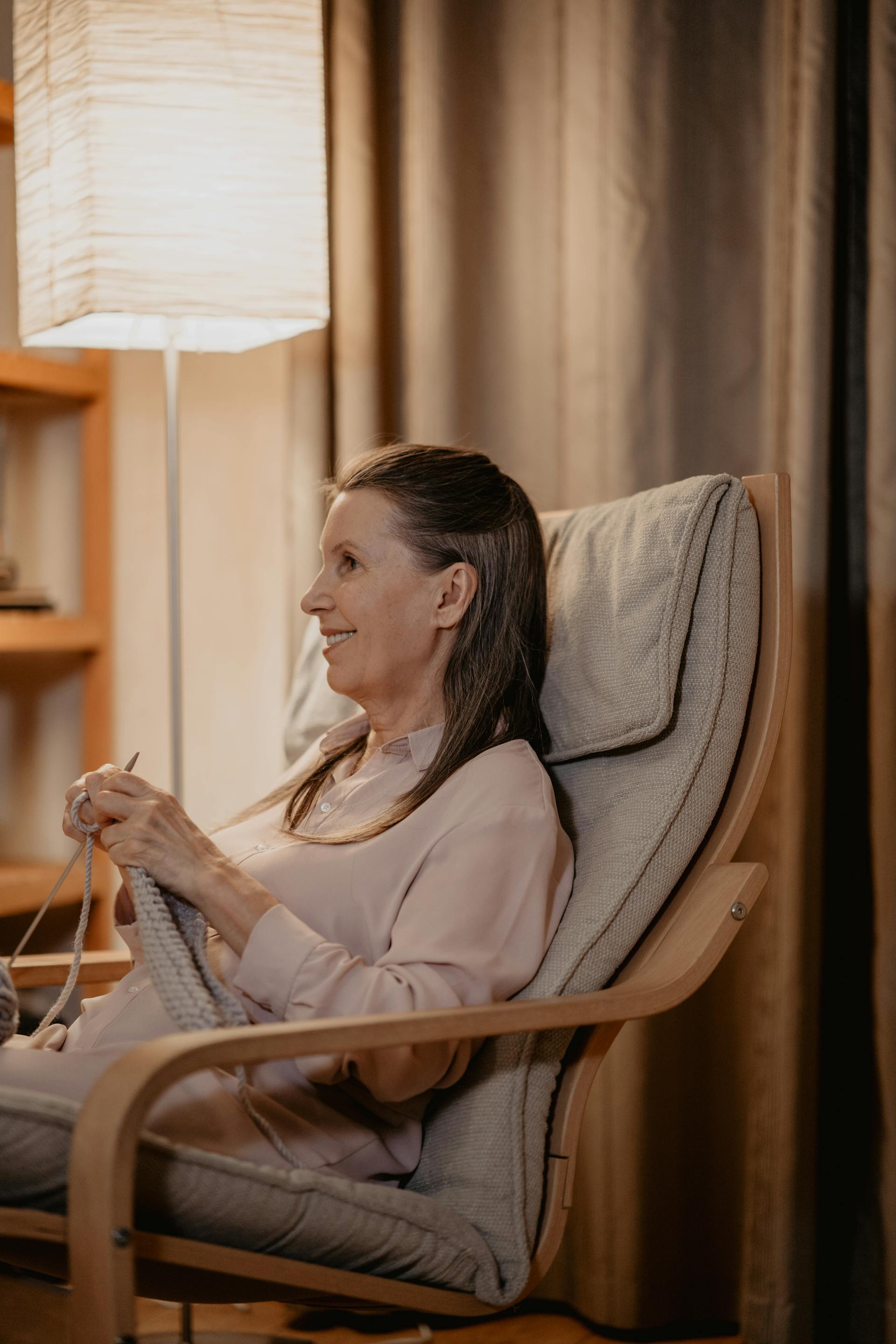 Una mujer mayor sentada en una silla y tejiendo | Fuente: Pexels