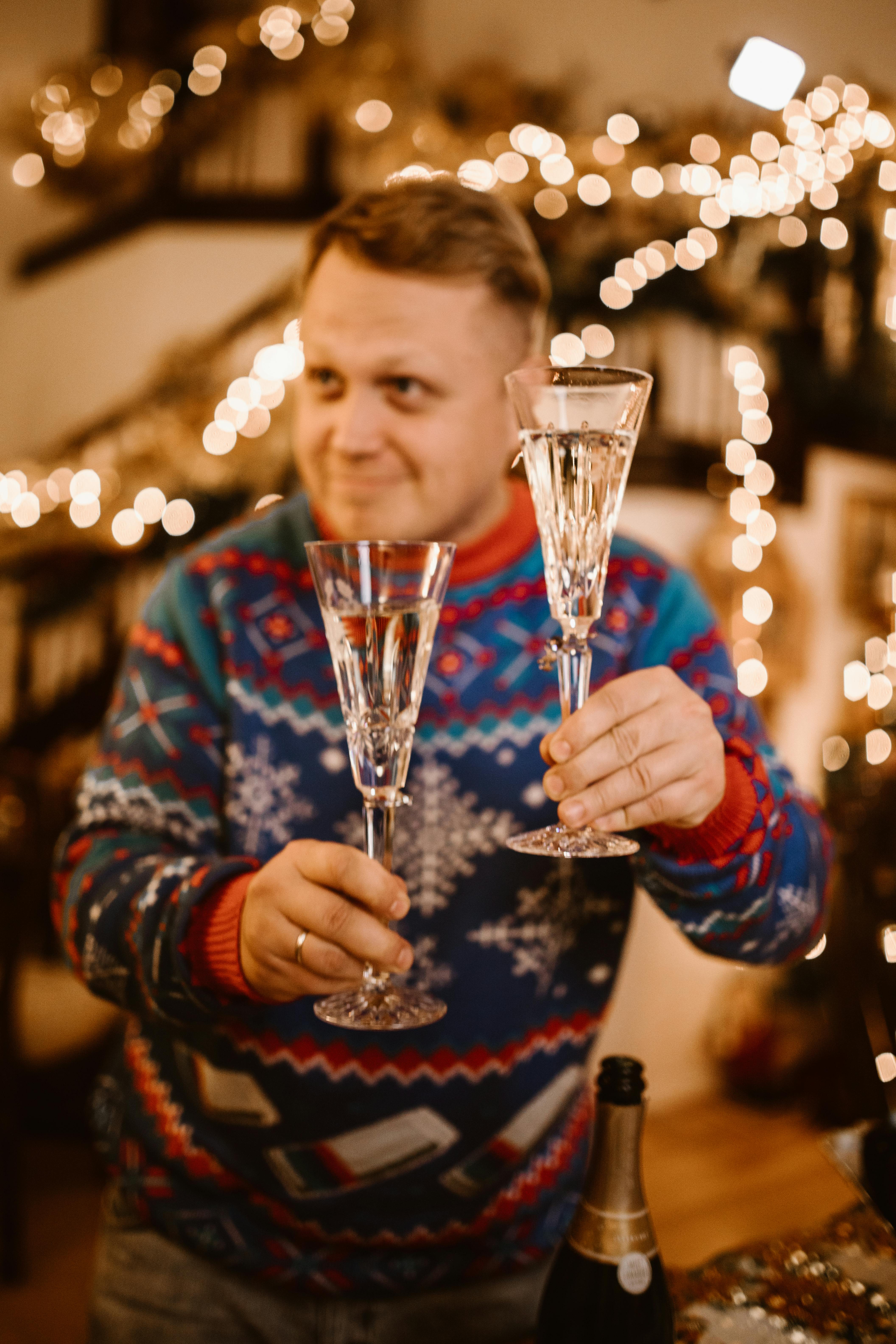 Un hombre sujetando copas de vino | Fuente: Pexels