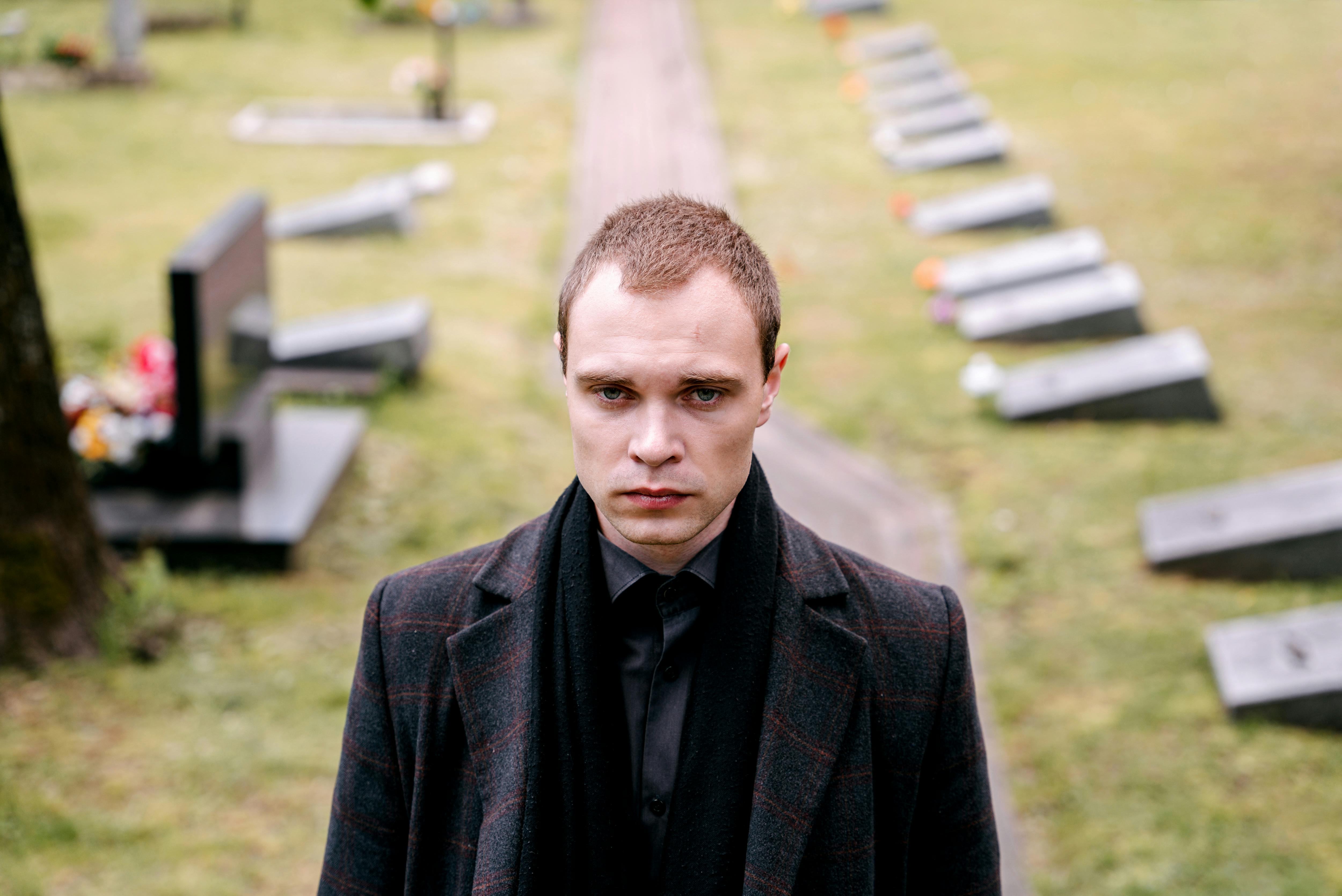 Un hombre de pie en un cementerio | Fuente: Pexels