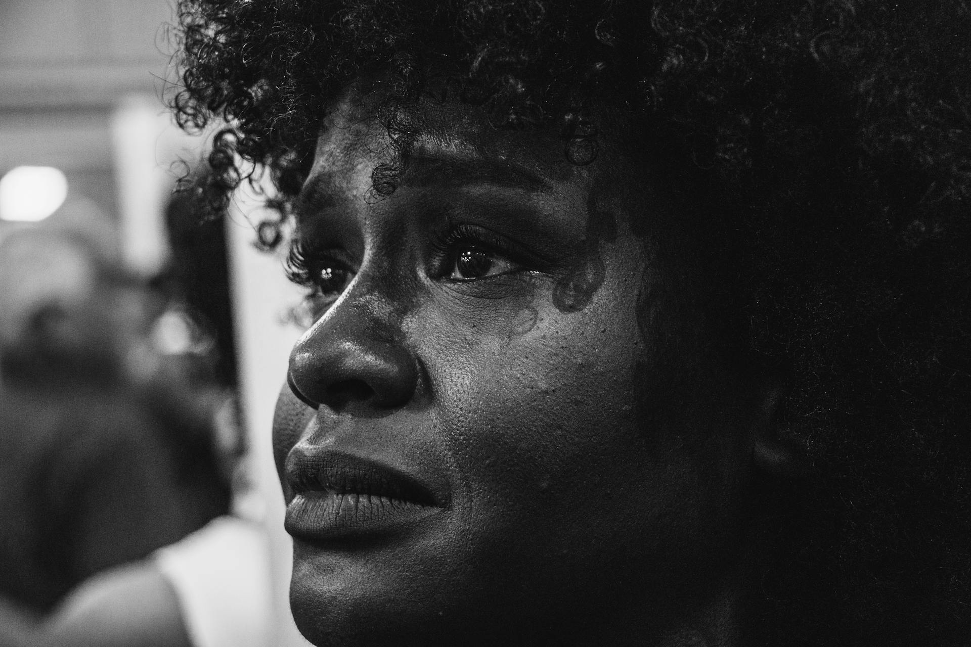 Una mujer con lágrimas en los ojos mirando a alguien | Fuente: Pexels