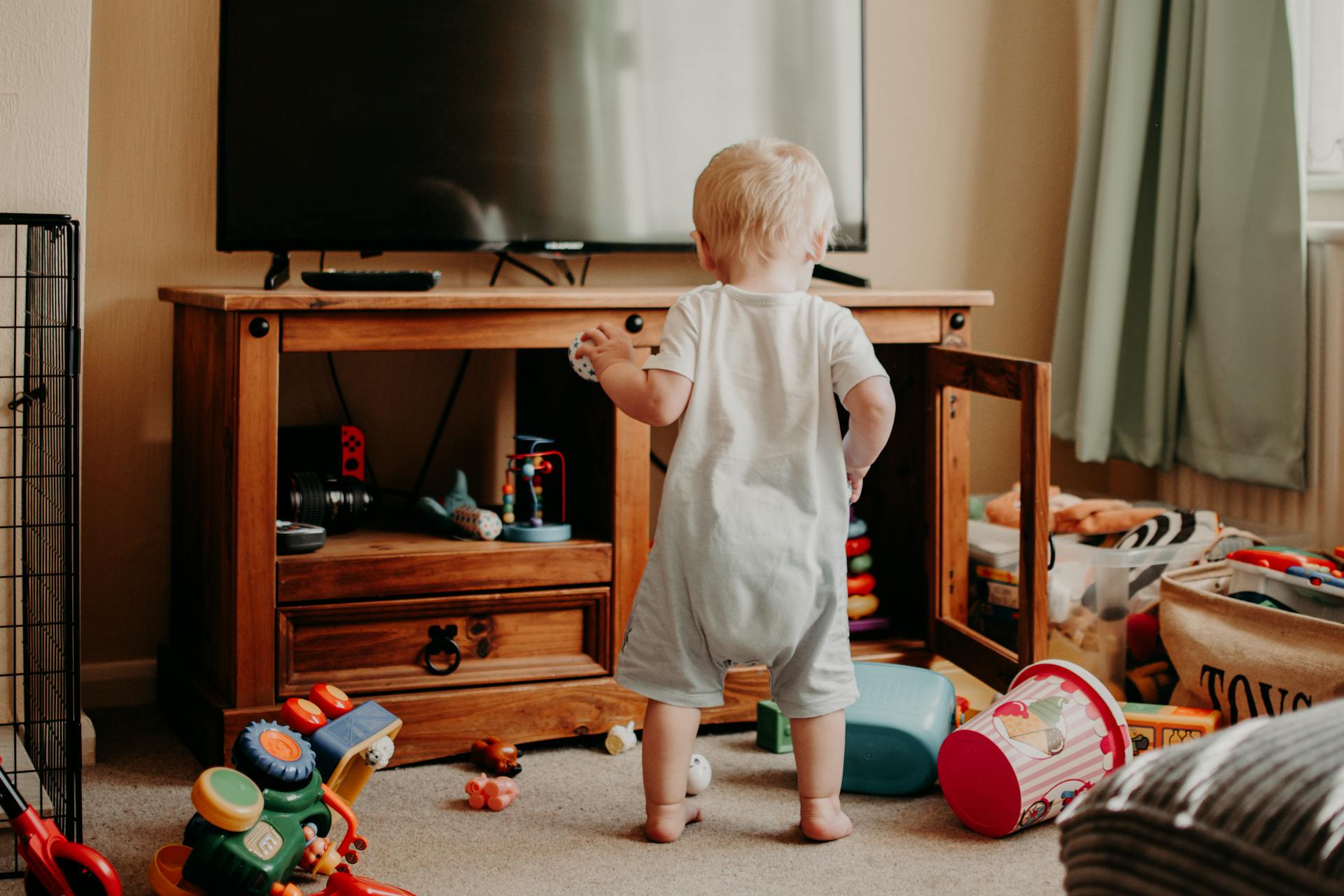 Un niño pequeño rodeado de juguetes en un salón | Fuente: Pexels