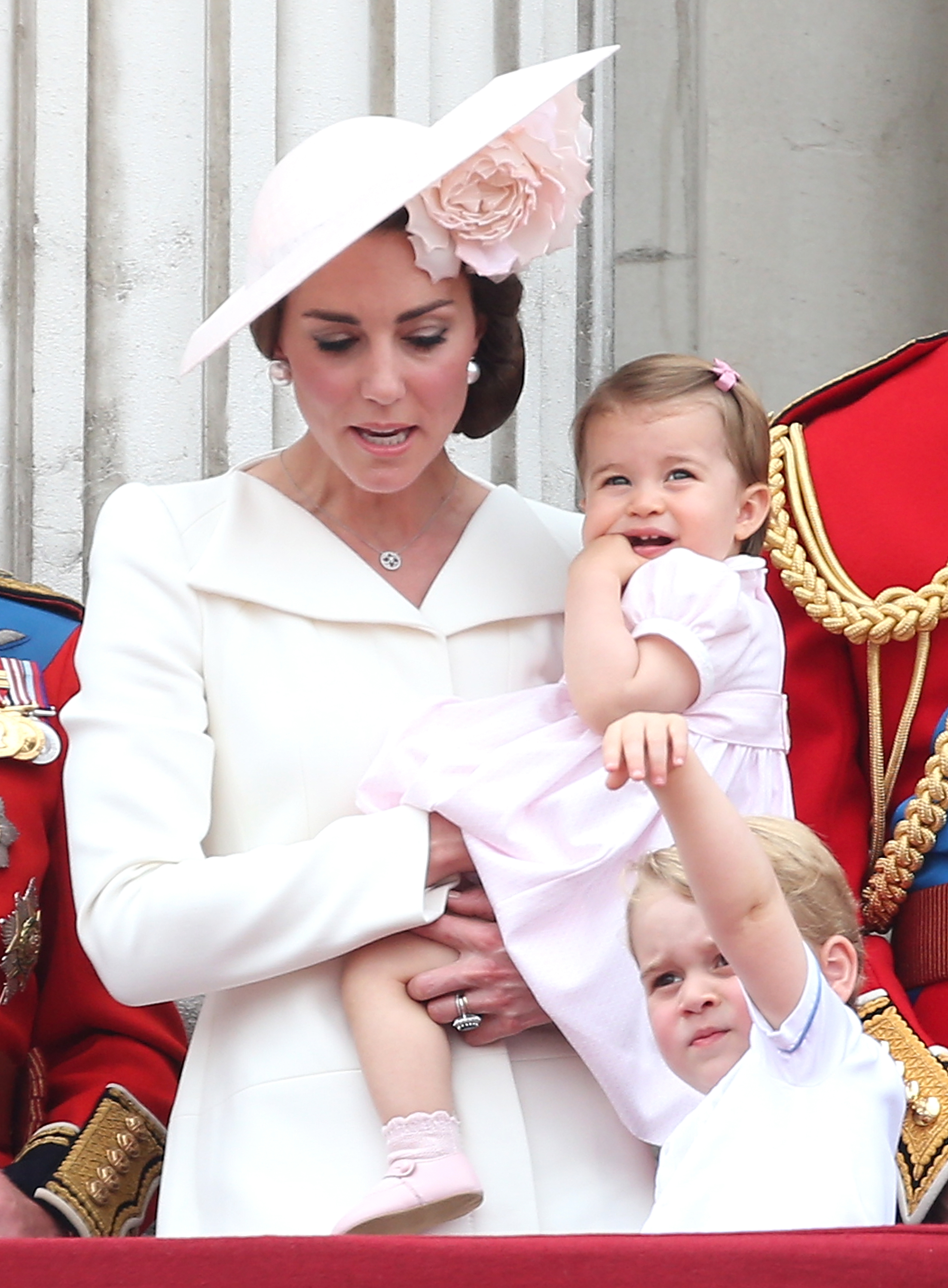Catherine, duquesa de Cambridge, sostiene en brazos a la pequeña princesa Charlotte mientras posa en el balcón junto al príncipe George durante el desfile