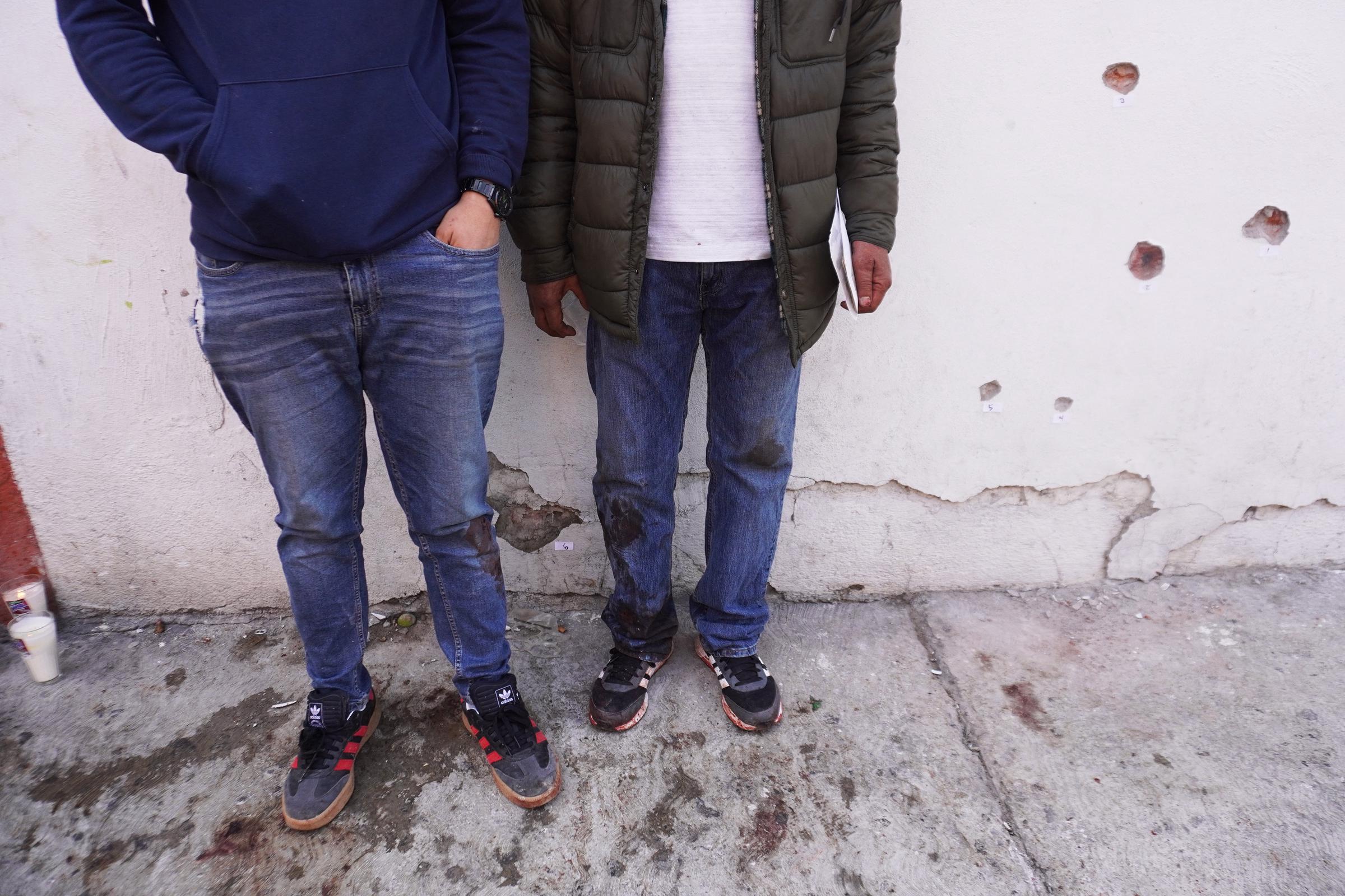 Hombres junto a agujeros de bala tras un tiroteo en Barrio Nuevo, en Irapuato, estado de Guanajuato, México, el 25 de junio de 2020. | Fuente: Getty Images