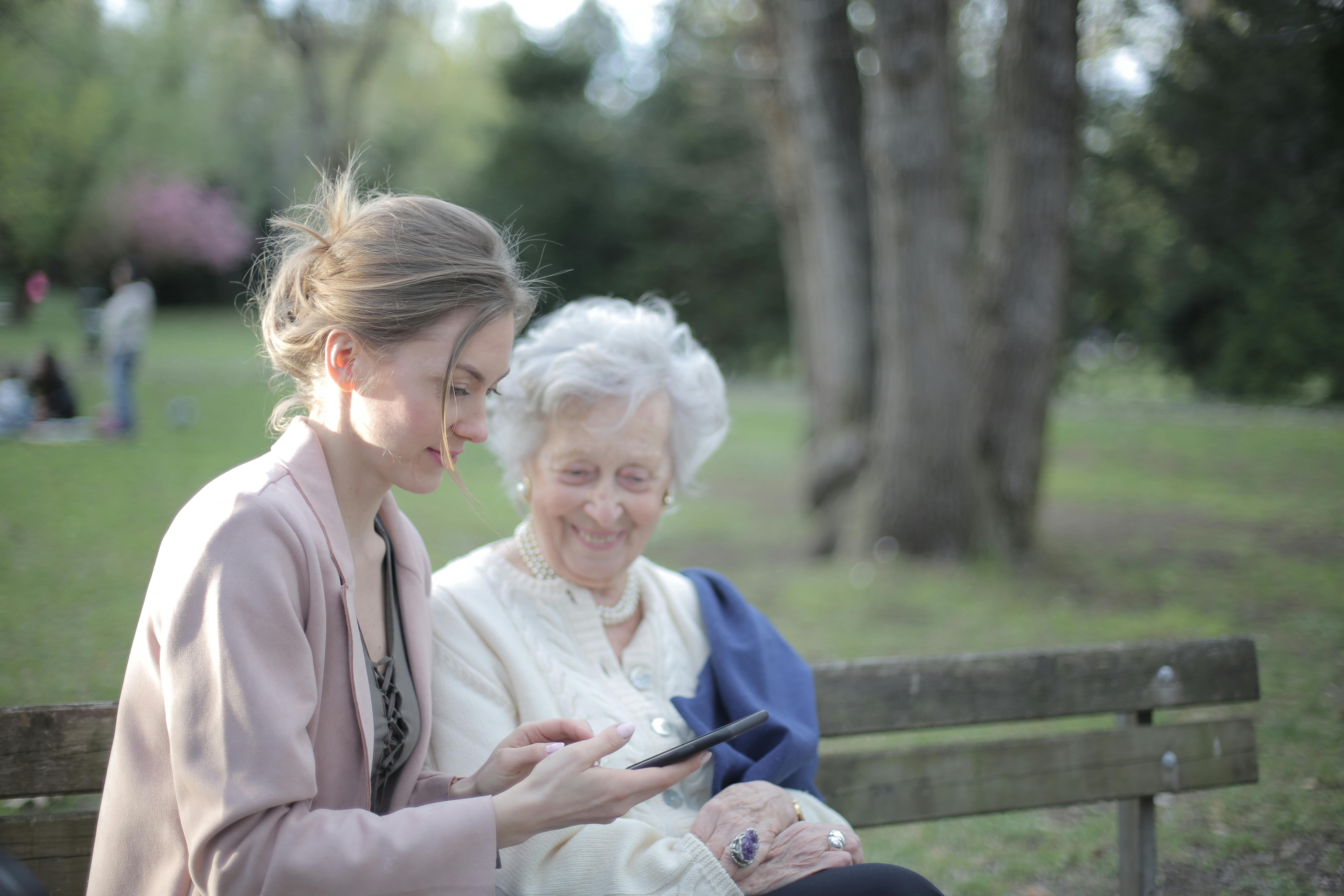 Anciana sentada con su hija al aire libre | Fuente: Pexels
