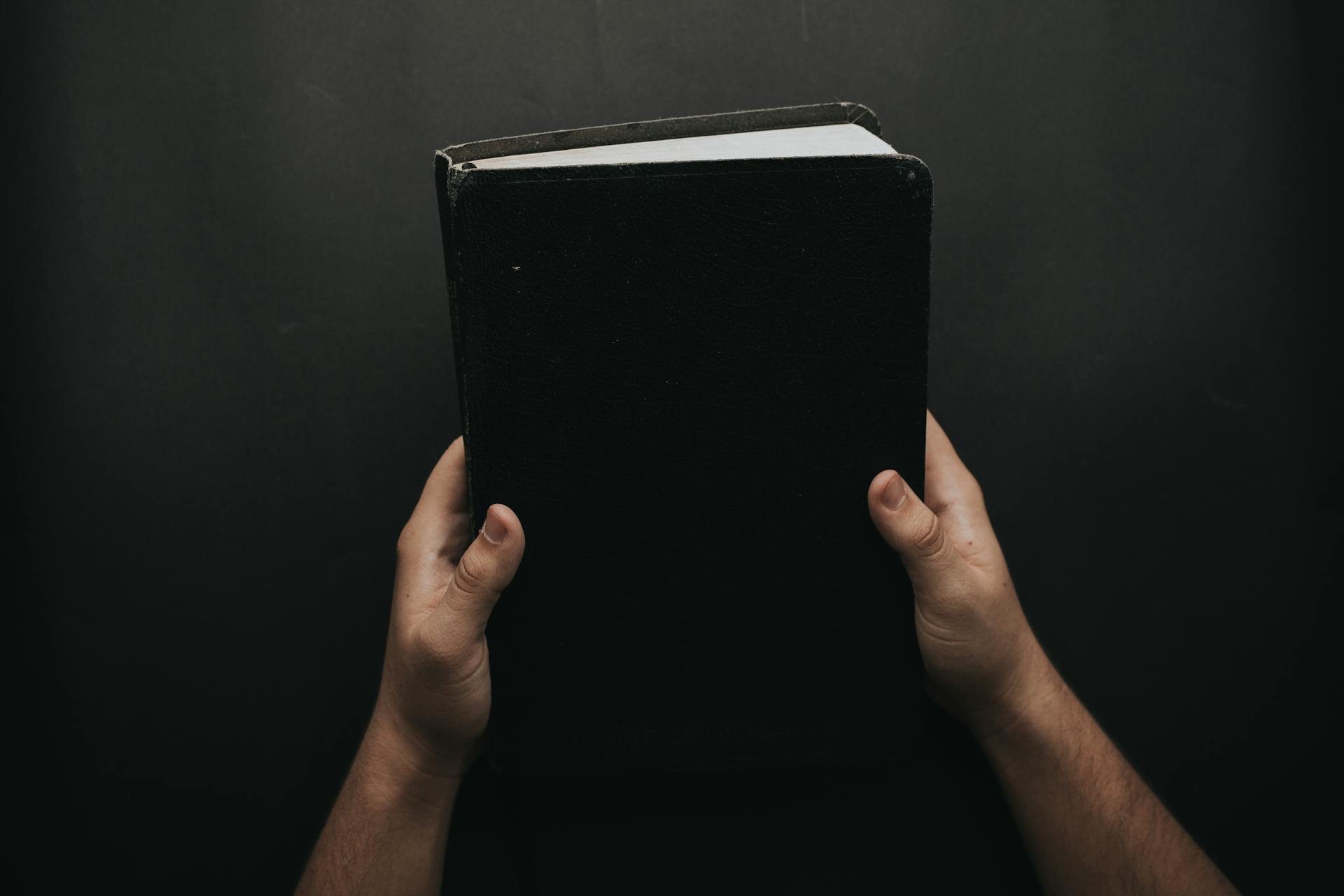 Un hombre con un libro en la mano | Fuente: Pexels