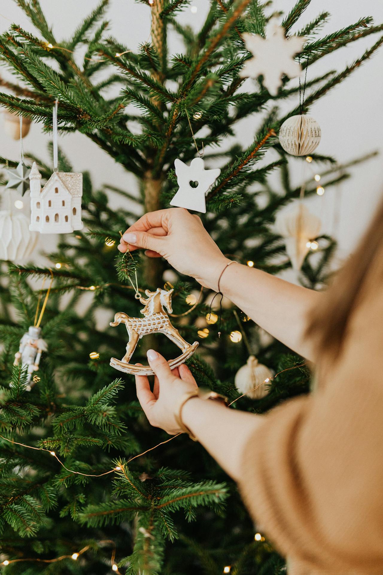 Una mujer decorando su árbol de Navidad | Fuente: Pexels