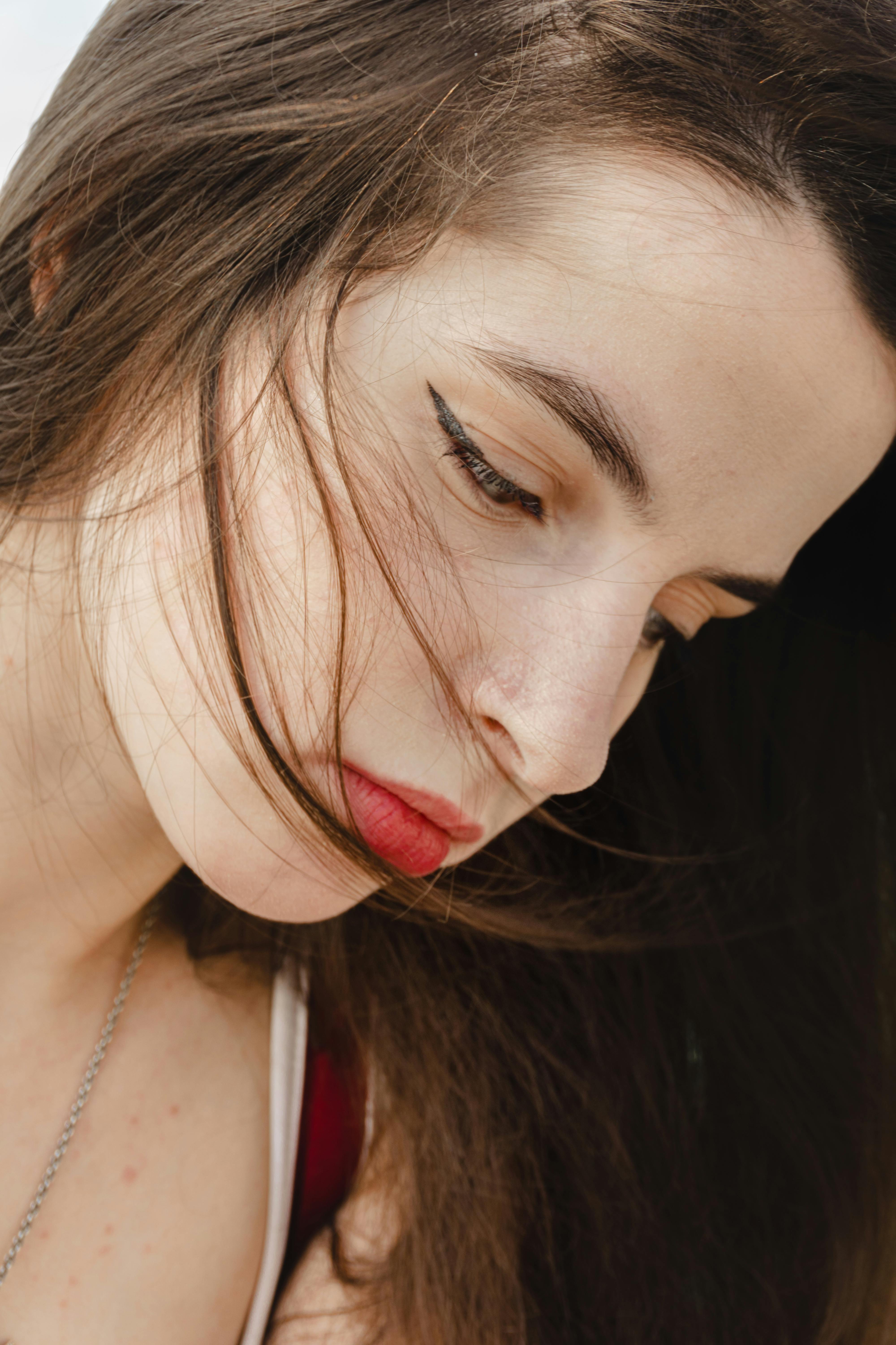 Una mujer triste mirando hacia abajo | Fuente: Pexels