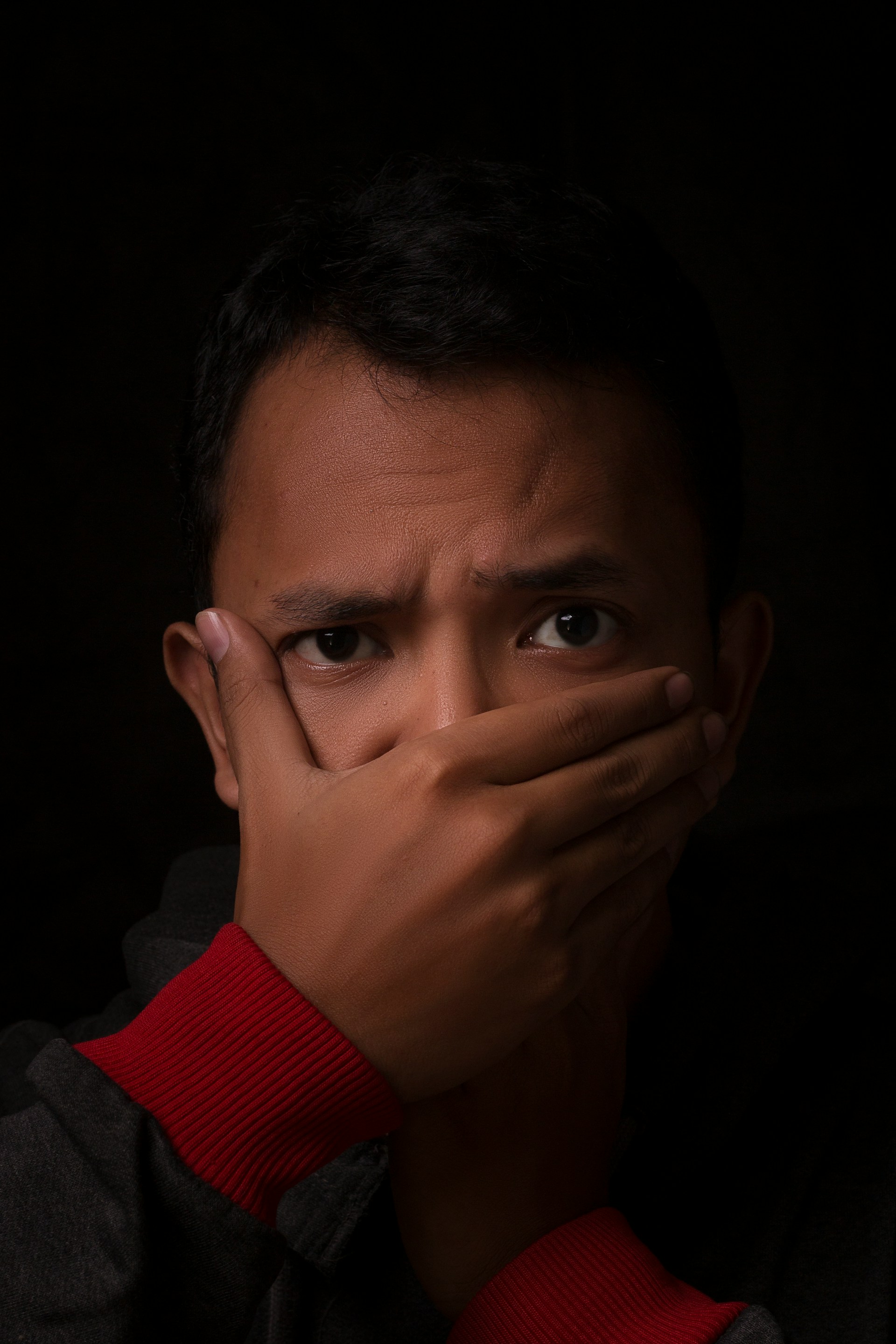 Un hombre tapándose la boca con una mano | Fuente: Unsplash
