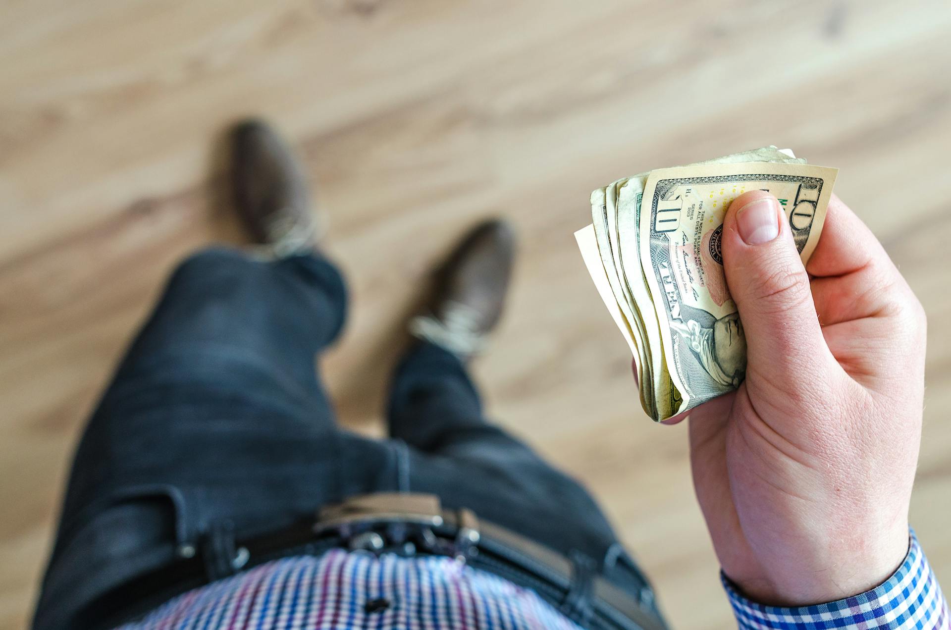 Un hombre sosteniendo billetes de dólar | Fuente: Pexels