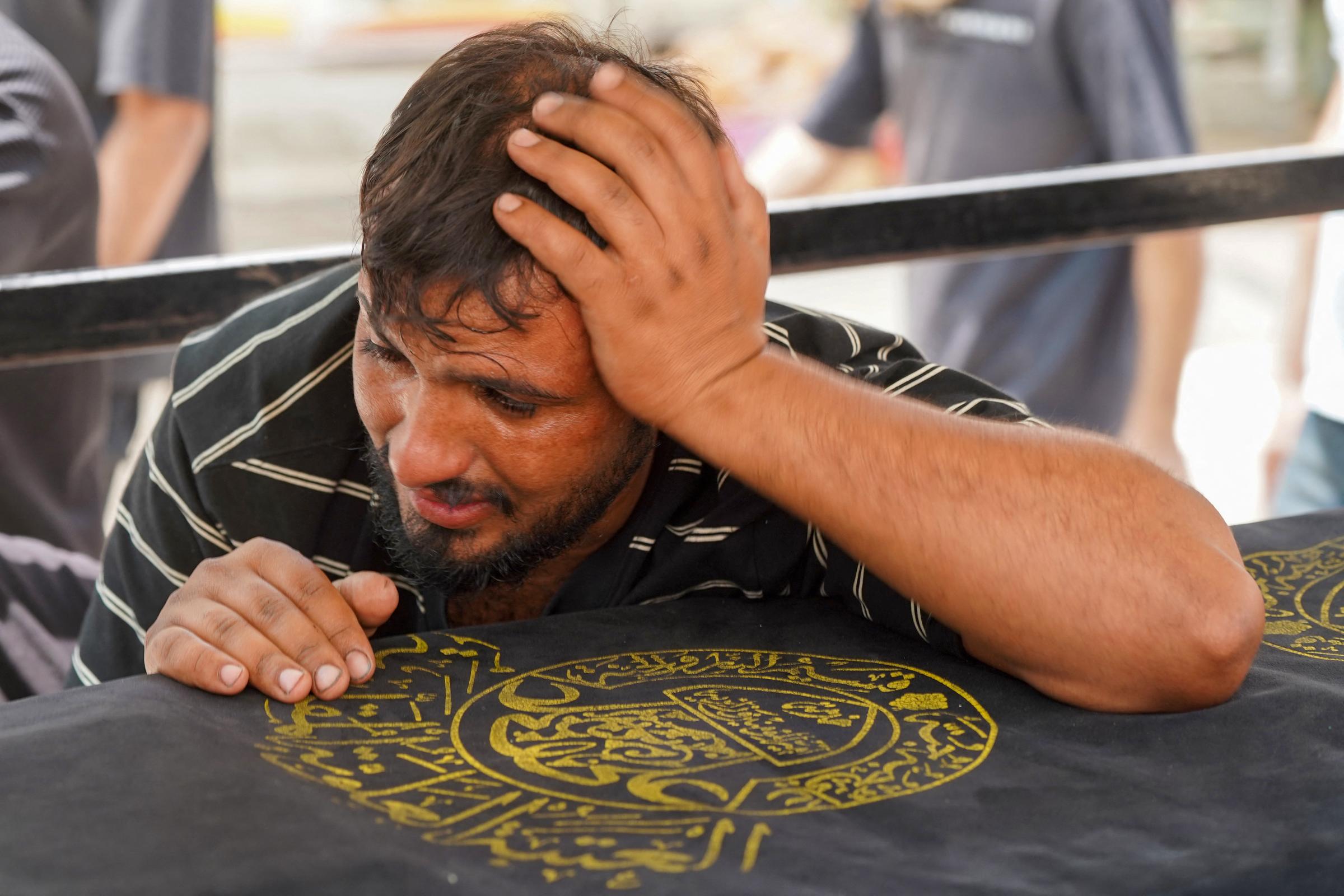 Un hombre llora sobre el ataúd de un familiar muerto en el incendio del Hyper Mall en Kut, Irak, el 17 de julio de 2025. | Fuente: Getty Images