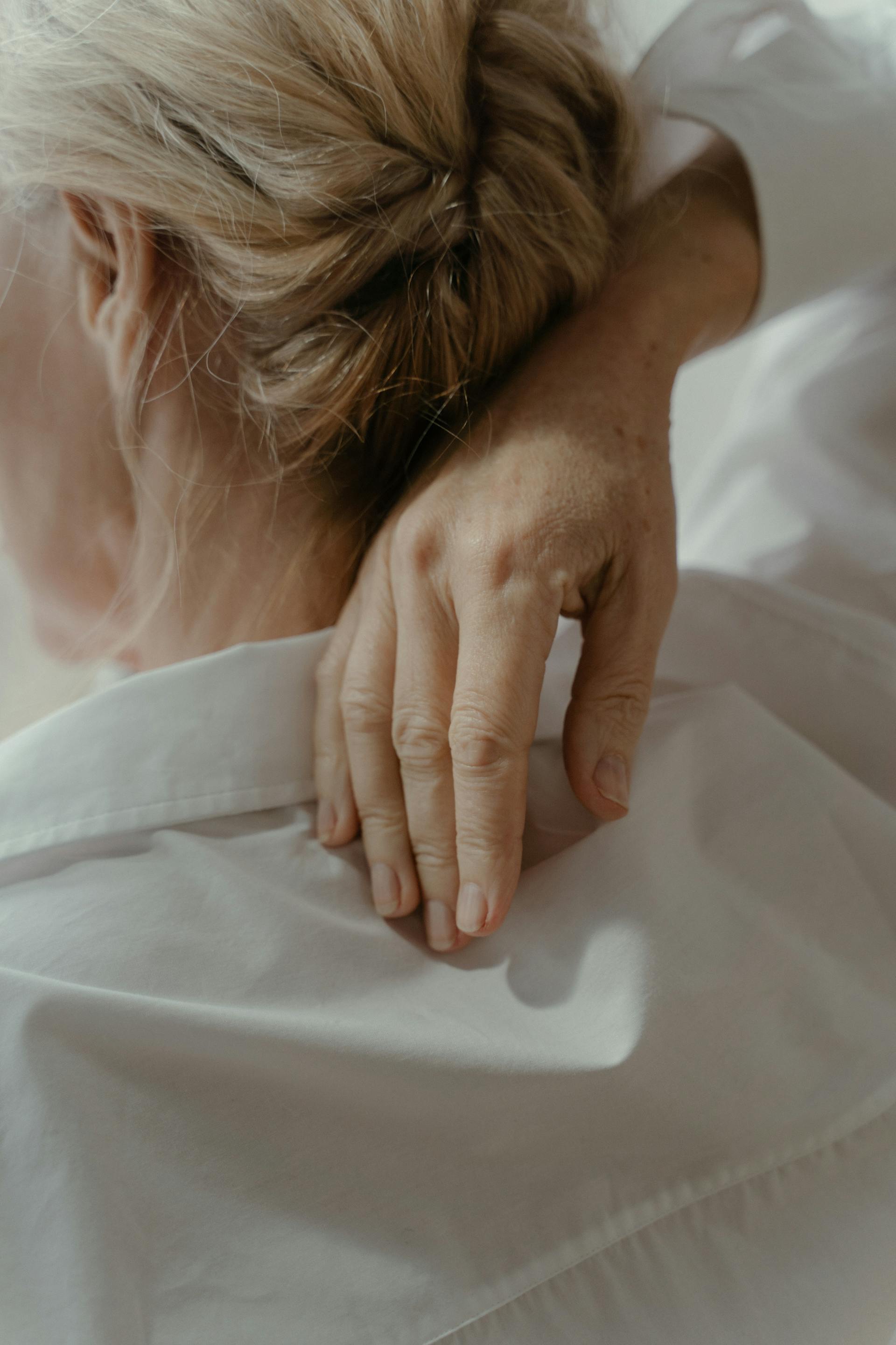 Una anciana tocándose la espalda con una mano | Fuente: Pexels